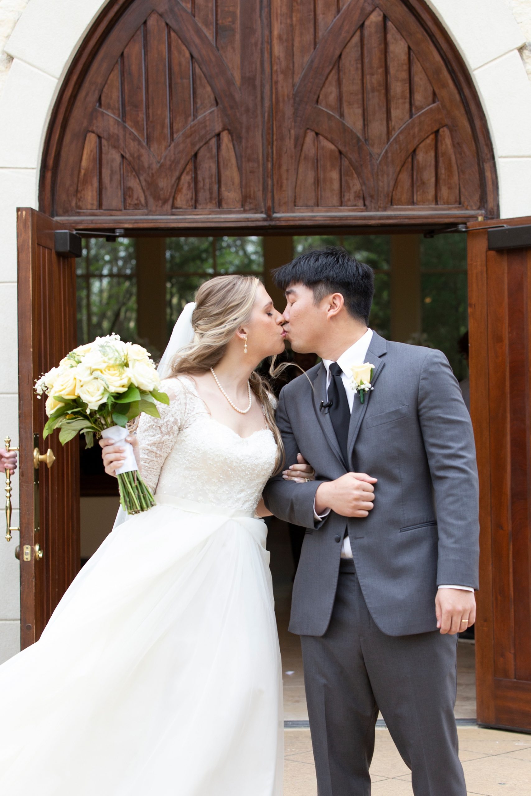 bride and groom kiss after leaving Ashton Gardens wedding chapel photographed by Randi Michelle Weddings