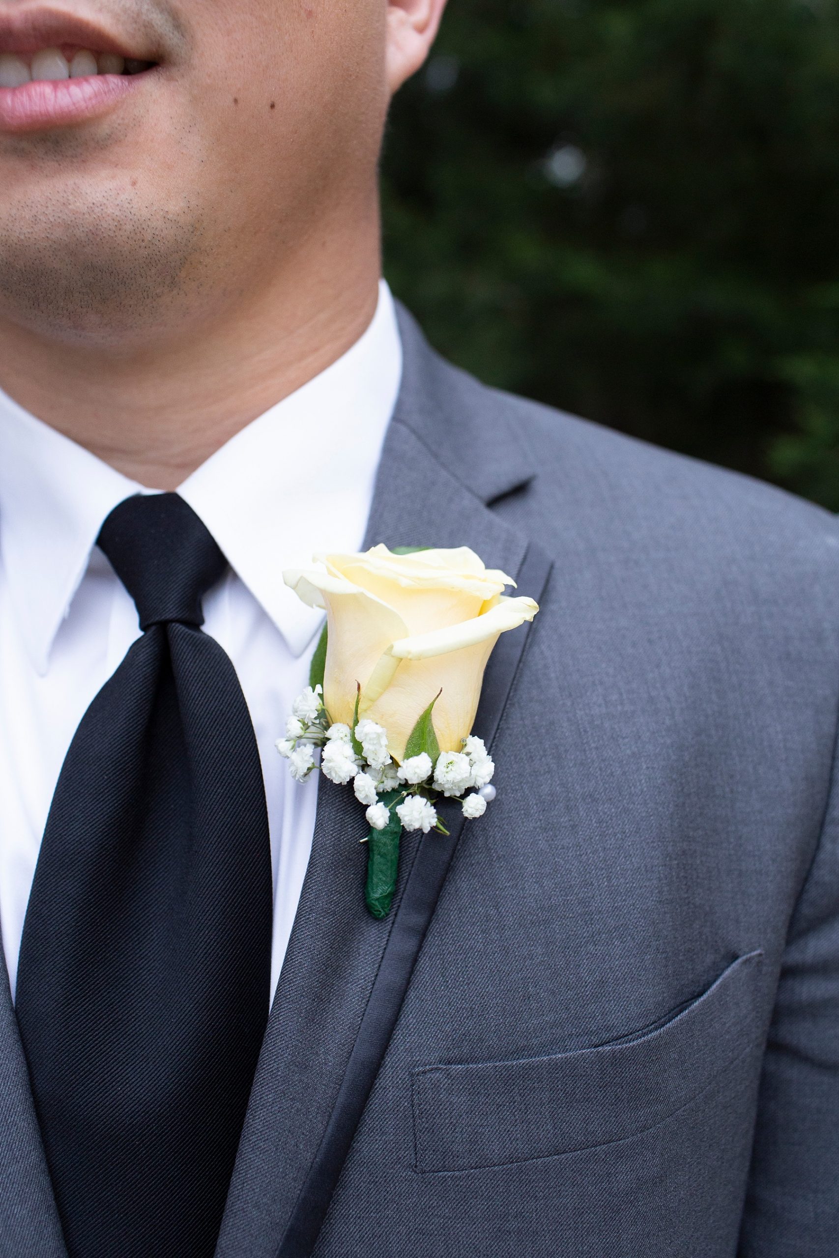 Randi Michelle Weddings photographs groom's suit with ivory rose boutonnière