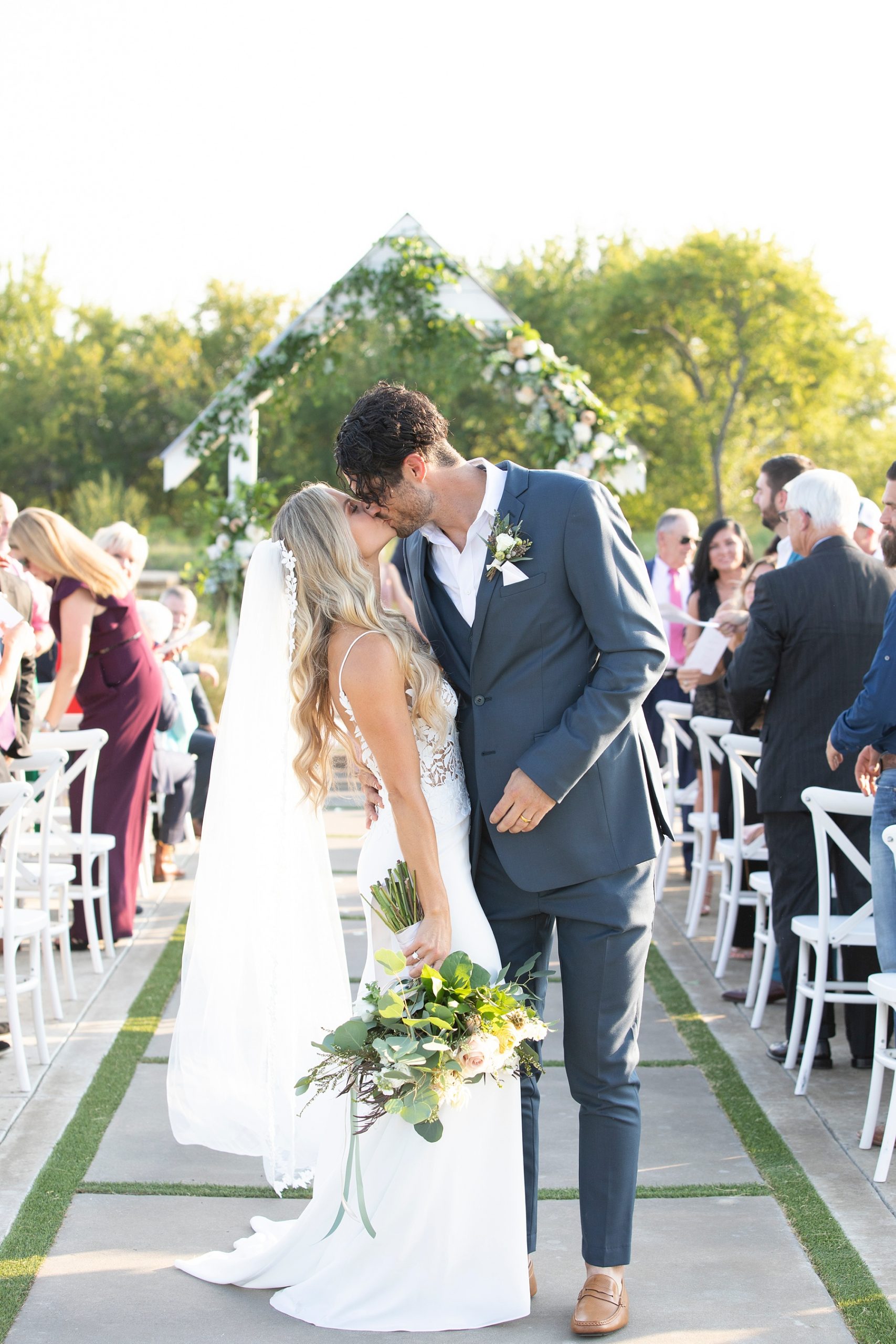 couple kisses at the end of the aisle photographed by Randi Michelle