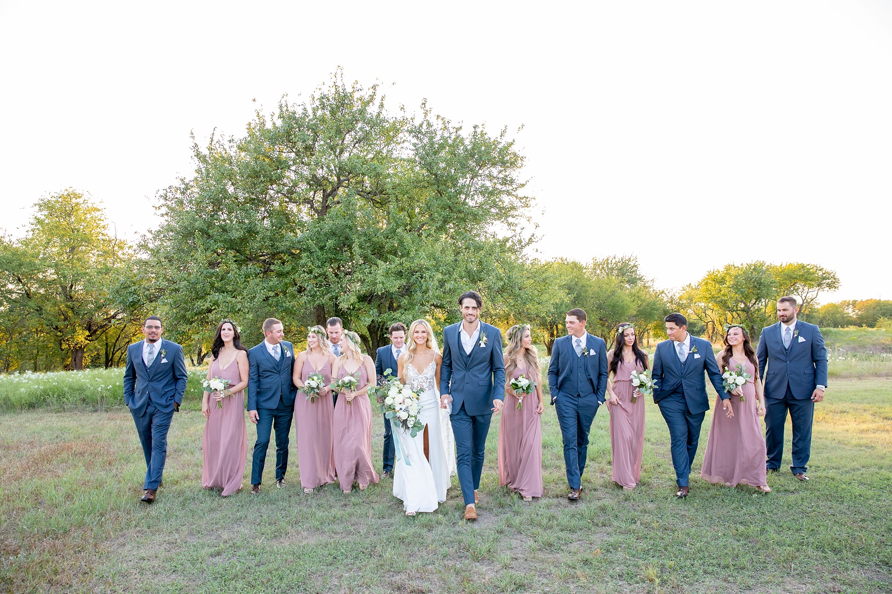 bridesmaids in pink gowns and groomsmen in blue suits photographed by Randi Michelle