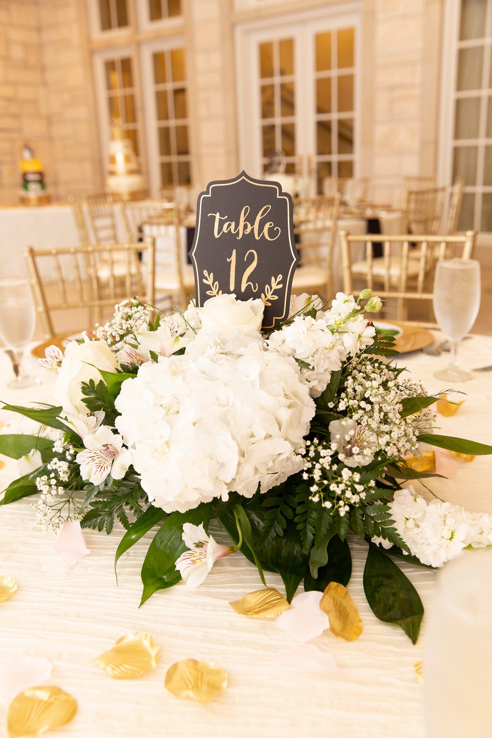 wedding centerpieces with ivory flowers and gold rose petals photographed by Randi Michelle Weddings