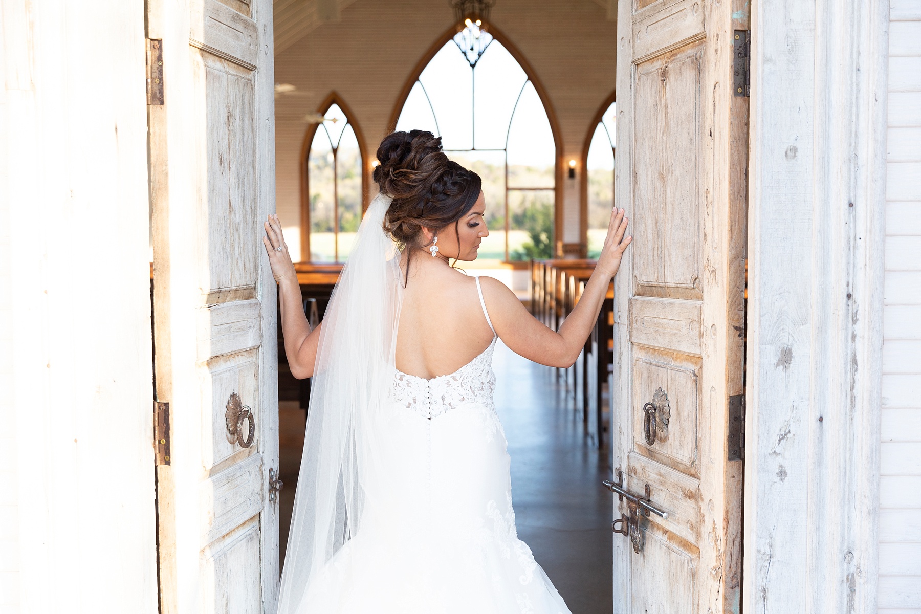 bride looks over shoulder at Randi Michelle during bridal portraits in Texas