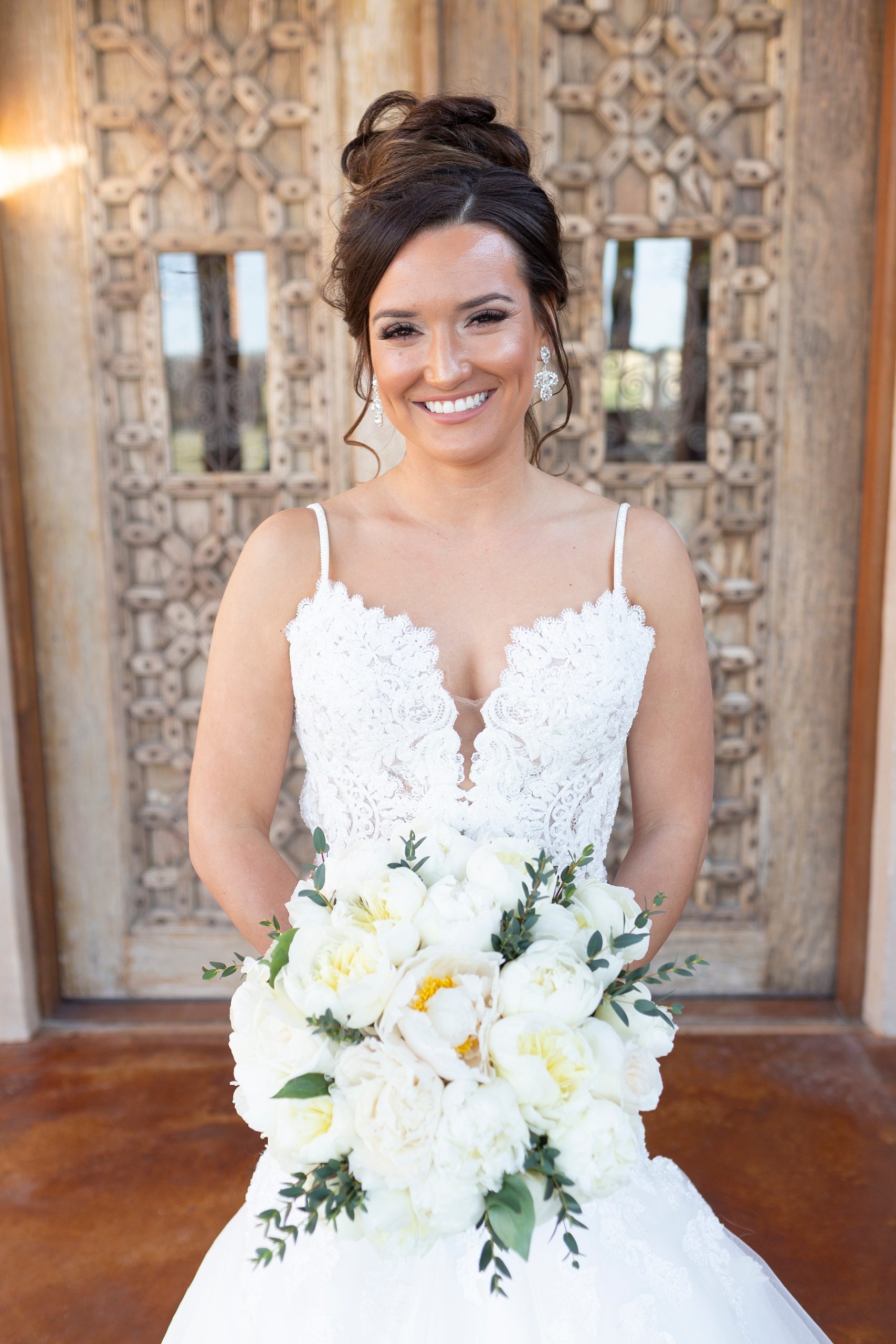 bride poses holding wedding bouquet at the Brooks at Weatherford photographed by Randi Michelle Weddings