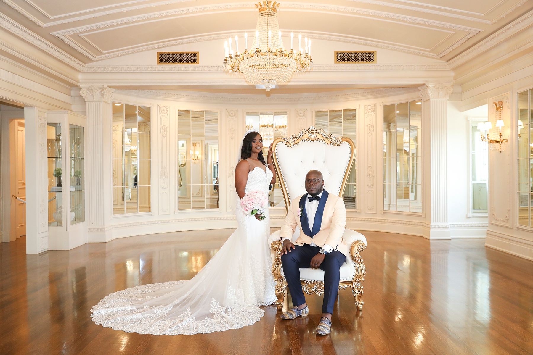 groom in tall wing back chair with bride photographed by Randi Michelle Weddings