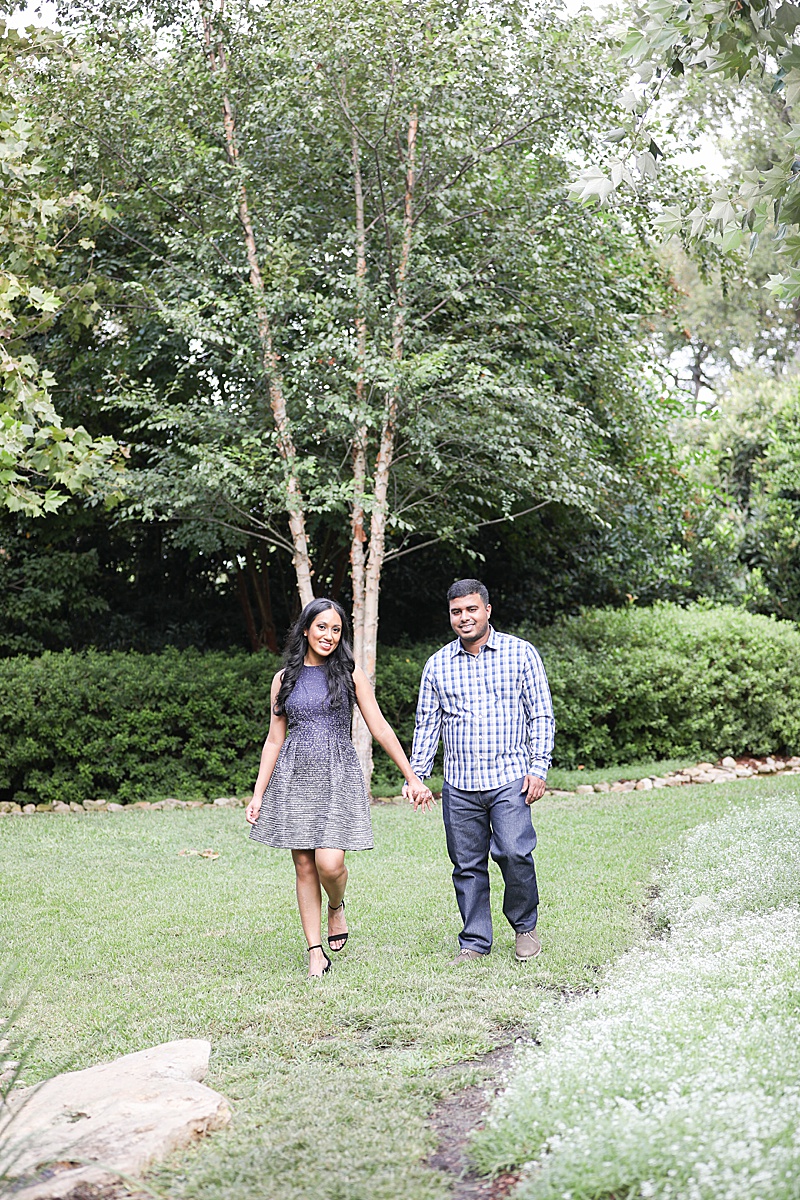 bride and groom hold hands and walk through grass at Dallas Arboretum