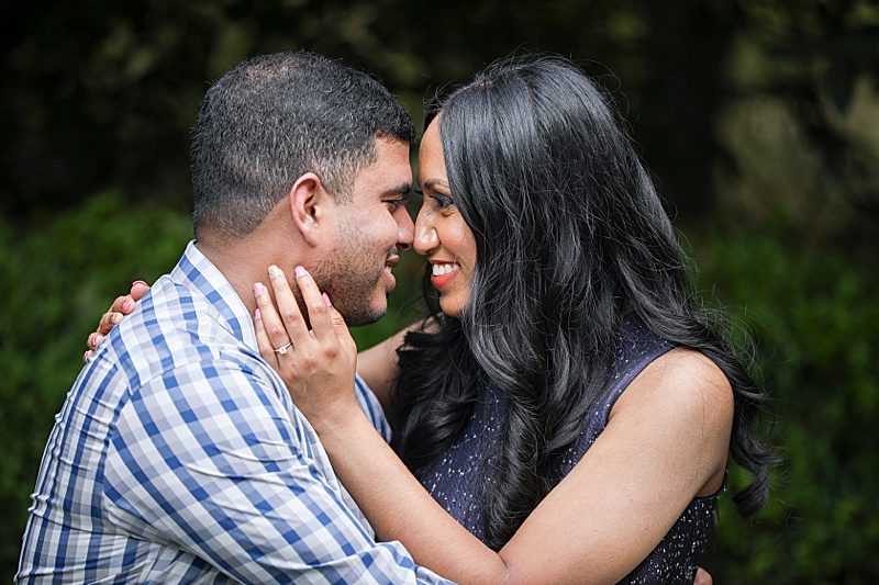 couple touches noses during engagement photos in Dallas Arboretum
