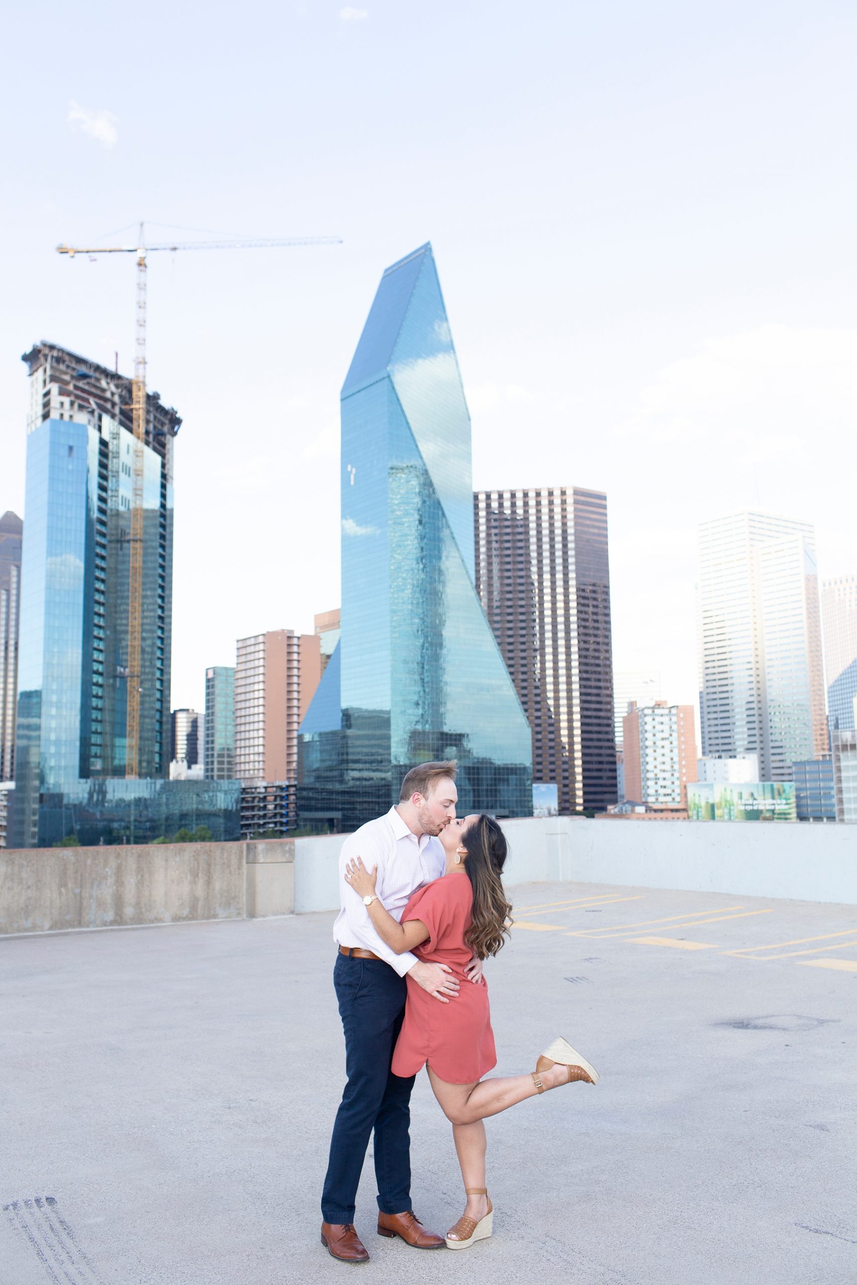 engaged couple poses in front of Dallas icons photographed by Randi Michelle Weddings