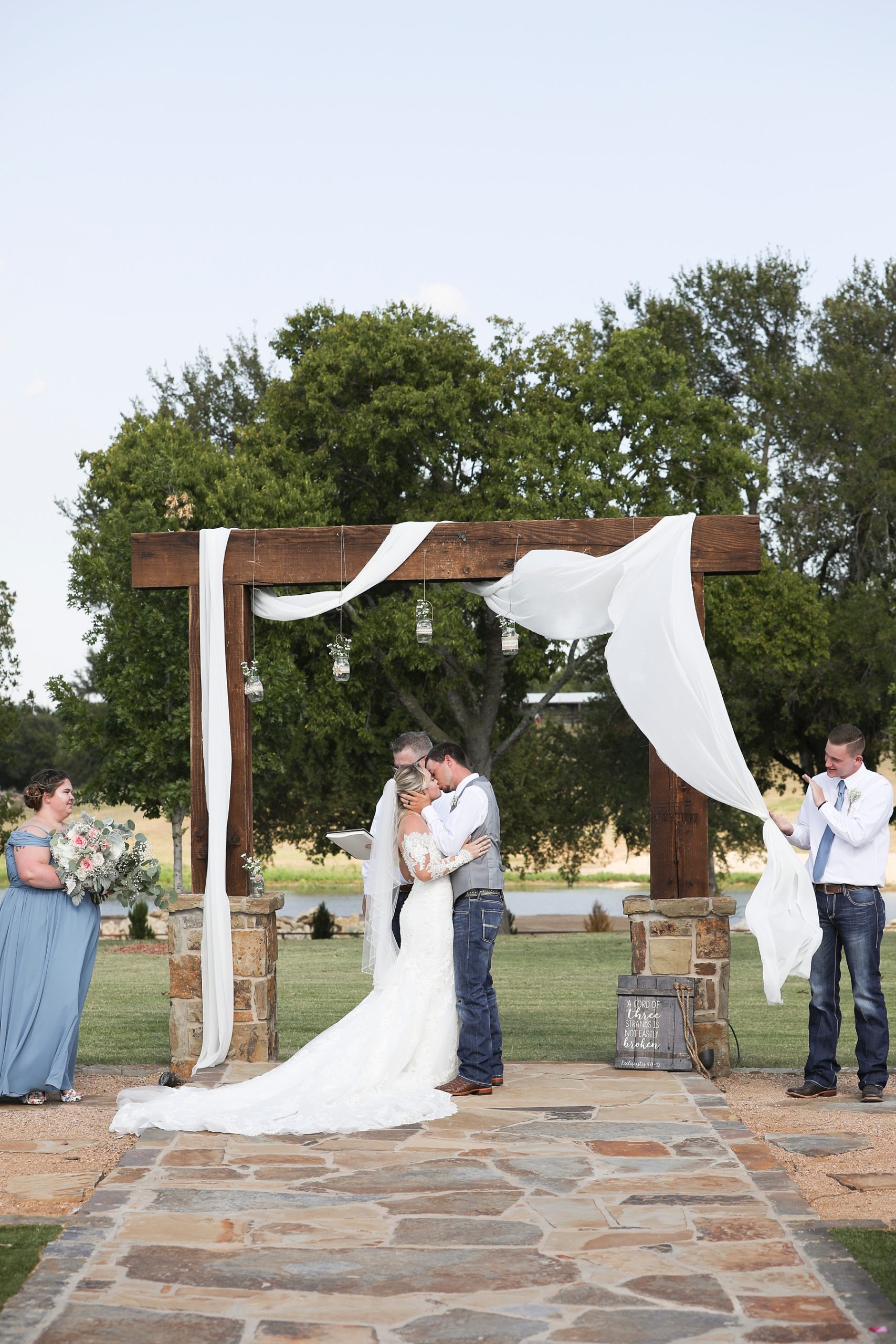 Texas wedding ceremony under wooden arbor photographed by Randi Michelle Weddings