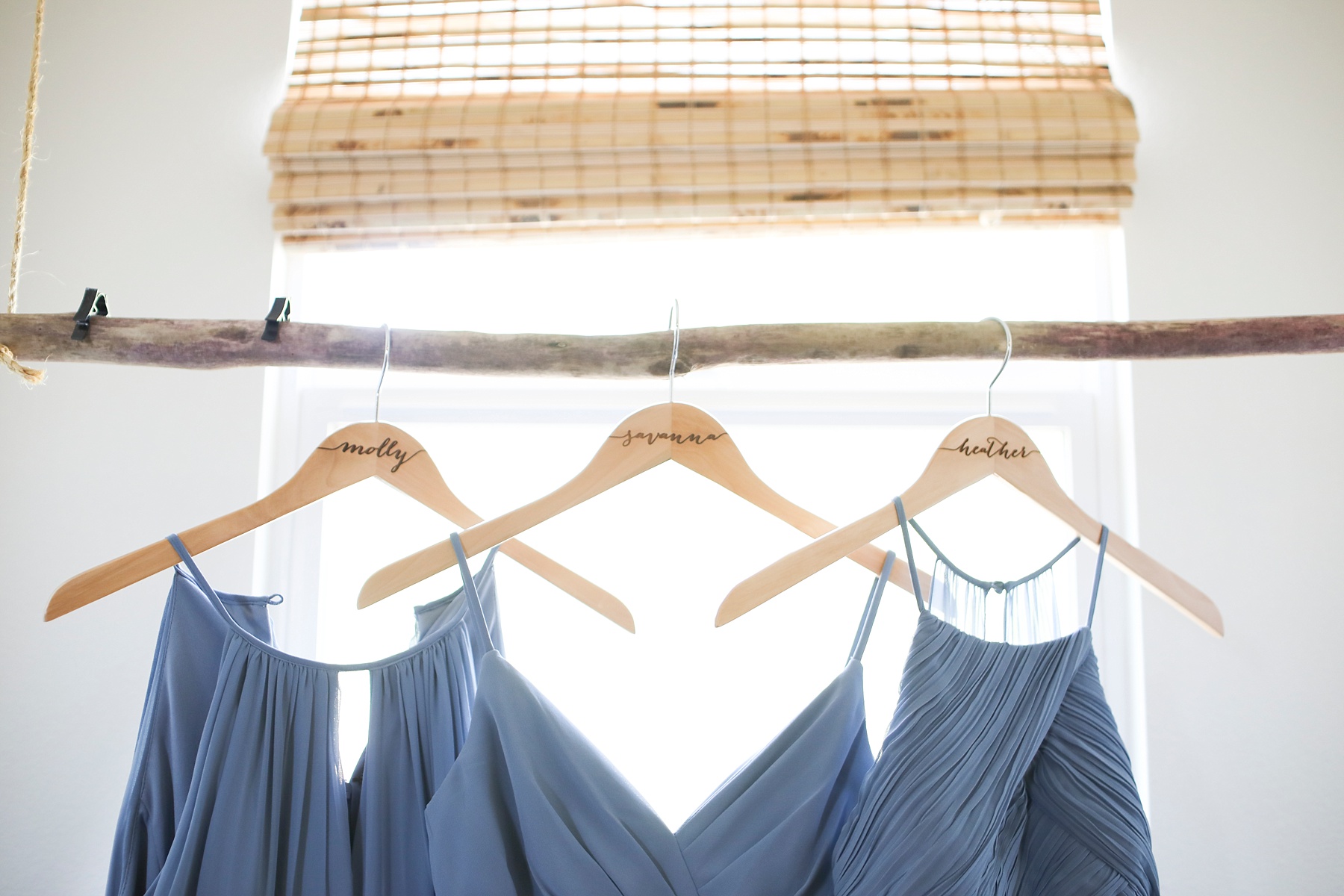 bridesmaids blue gowns hang in bridal suite