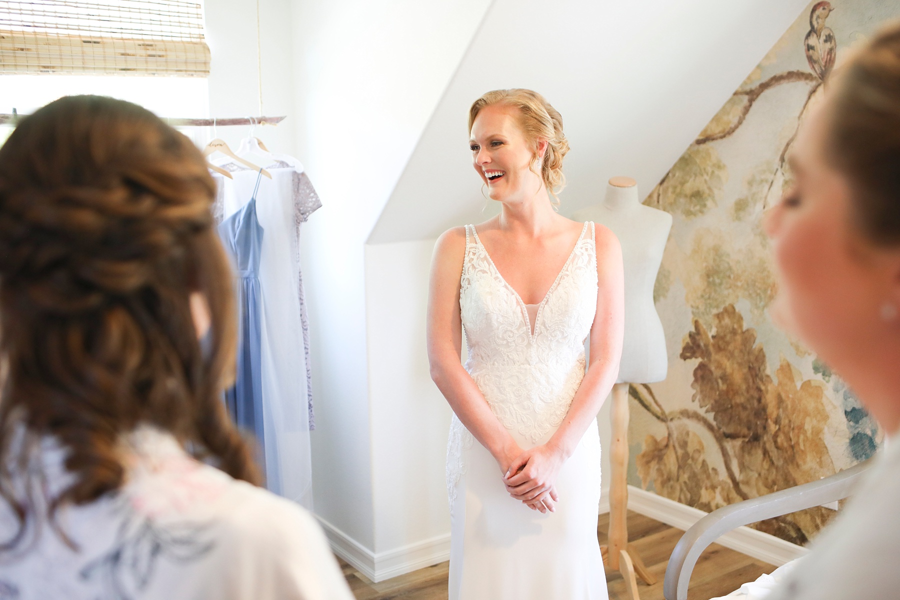 bride shows wedding dress to bridesmaids for the first time photographed by Randi Michelle Weddings