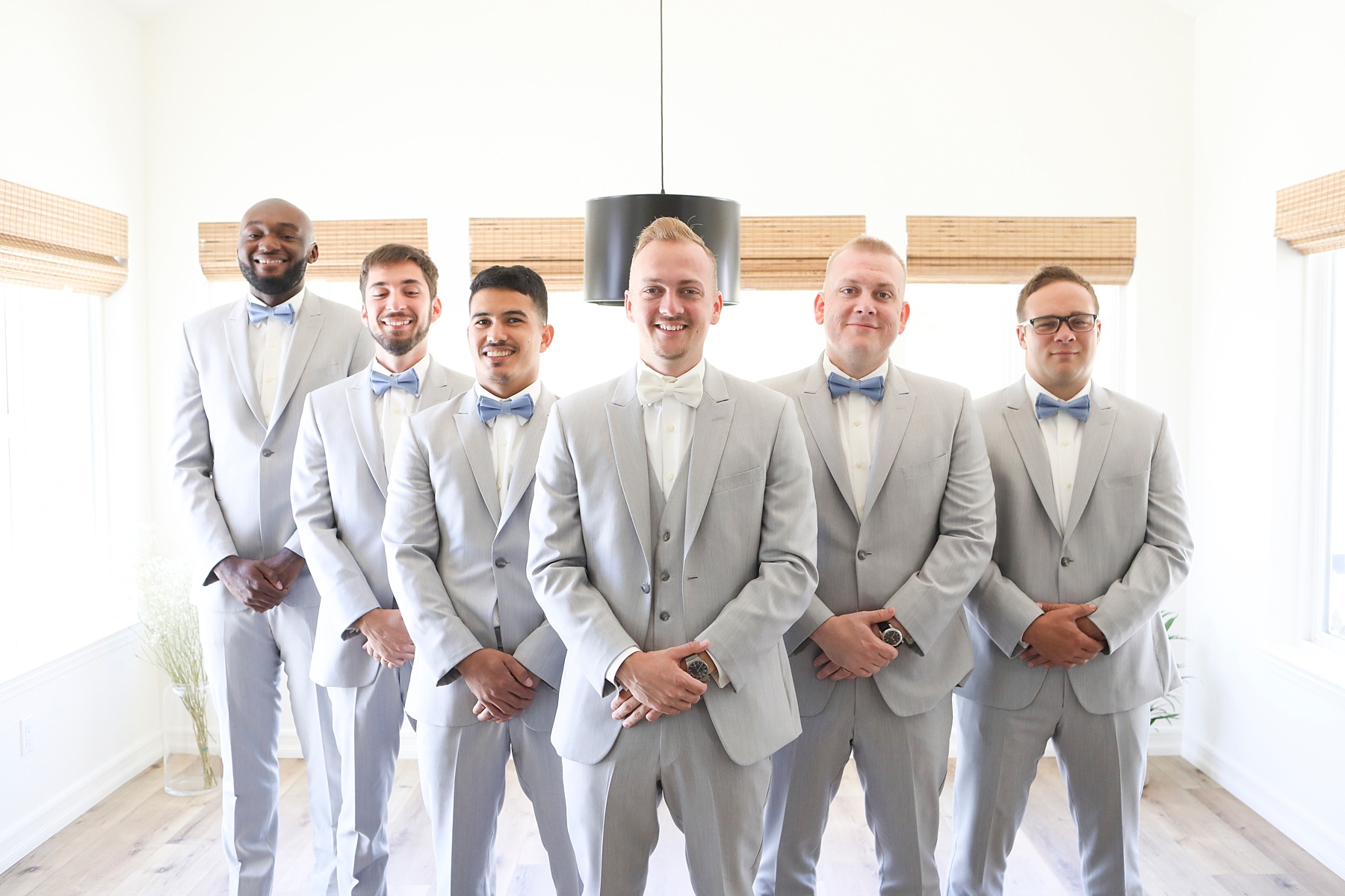 groomsmen pose with groom inside California wedding venue