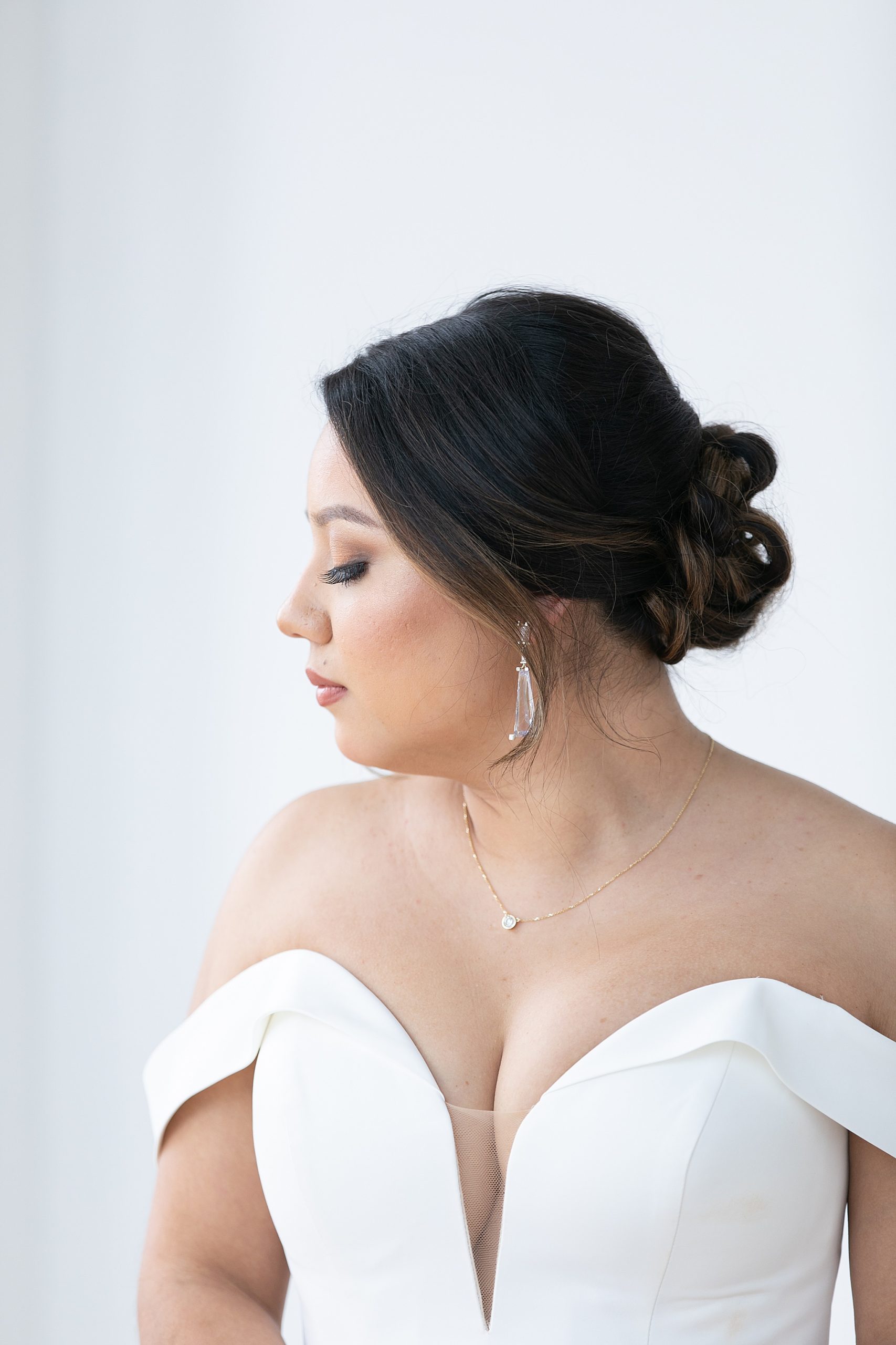 bride in strapless wedding gown looks over shoulder