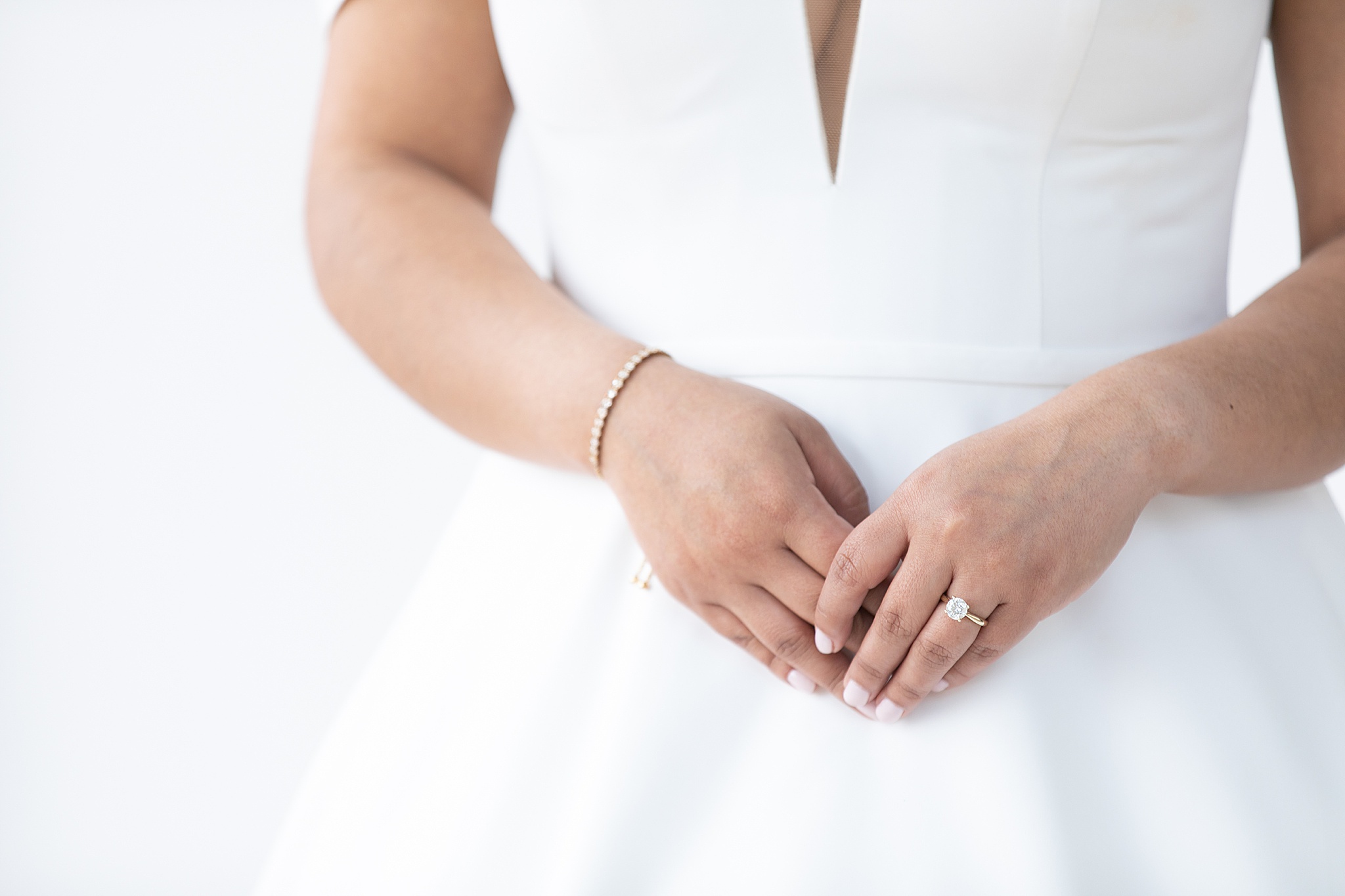 bride holds hands together, showing off engagement ring