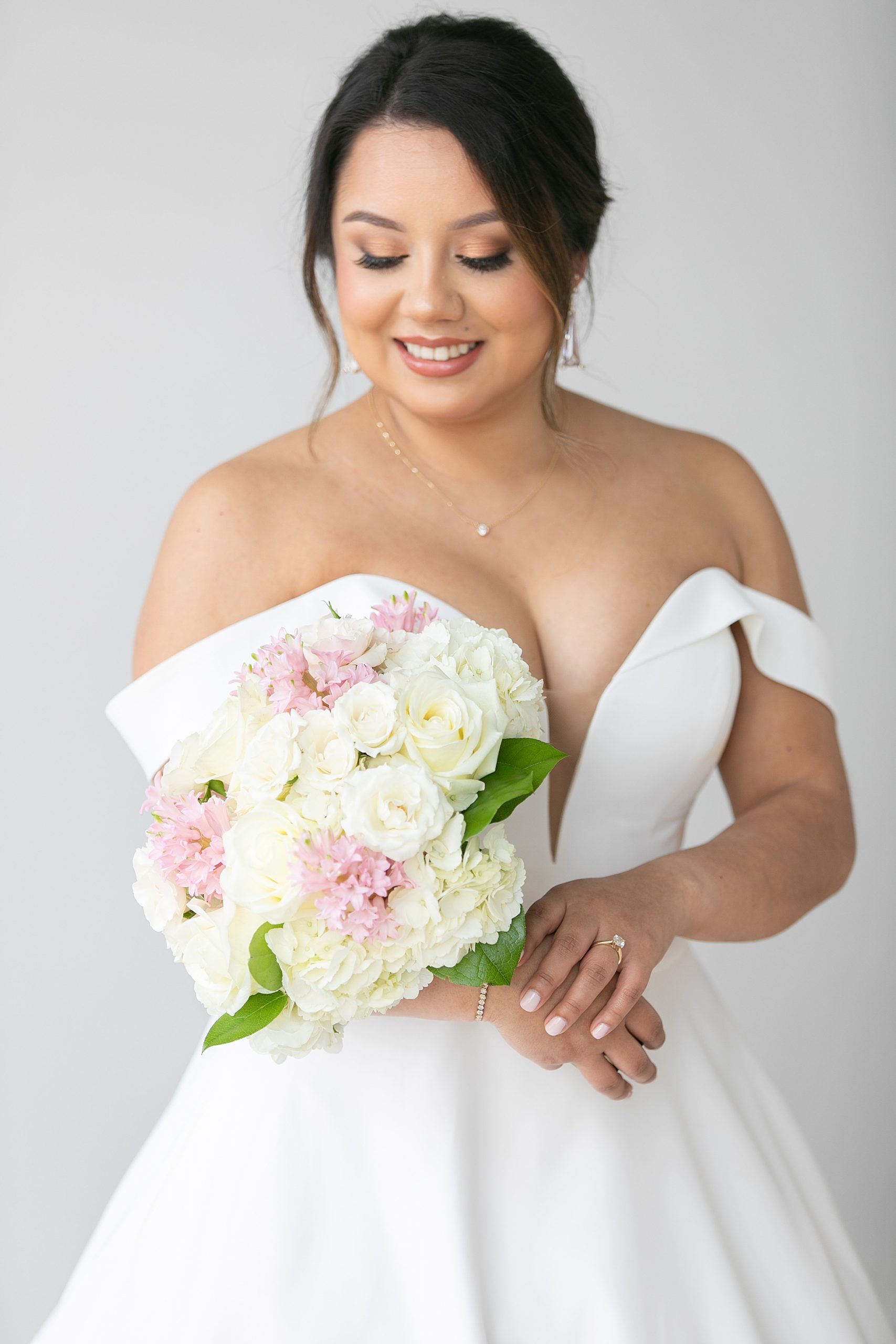 bride looks over shoulder at wedding bouquet in Dallas Lumen Room