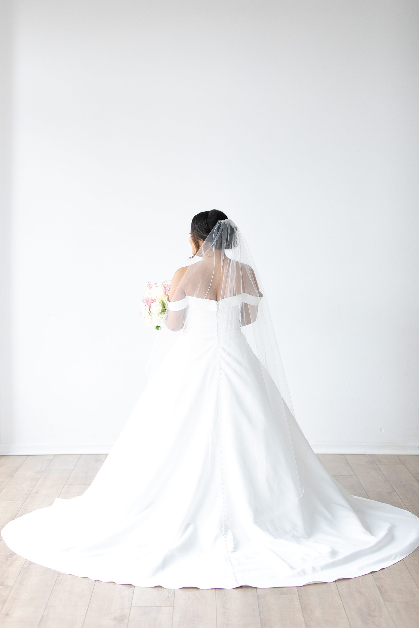 bride with veil poses in Dallas Lumen Room