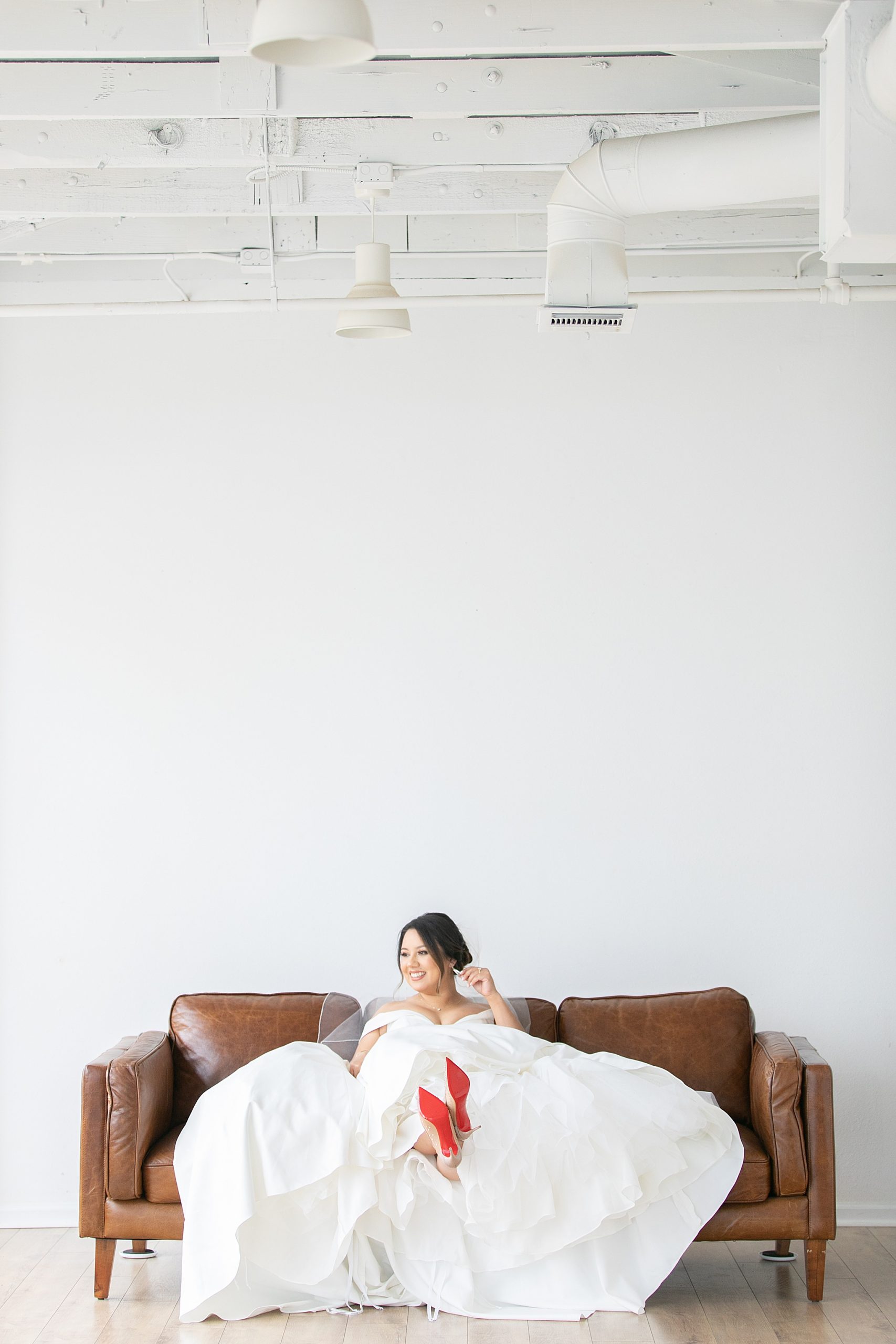 relaxed Dallas Lumen Room bridal portraits with bride resting feet on couch