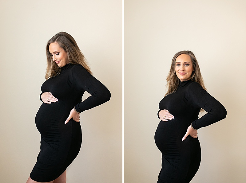 mom in black dress holds baby bump at home