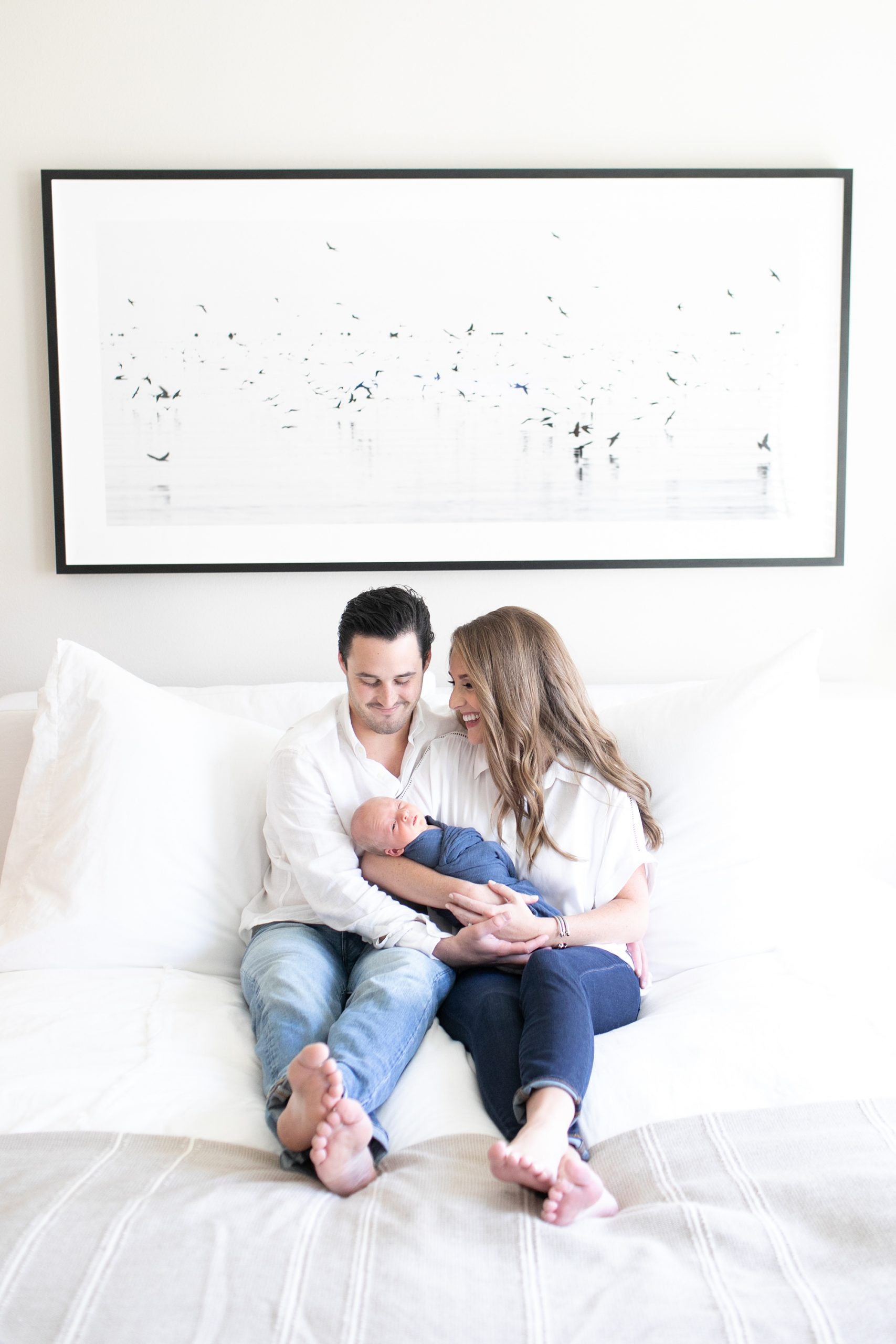 Dallas TX family poses on bed during lifestyle newborn session