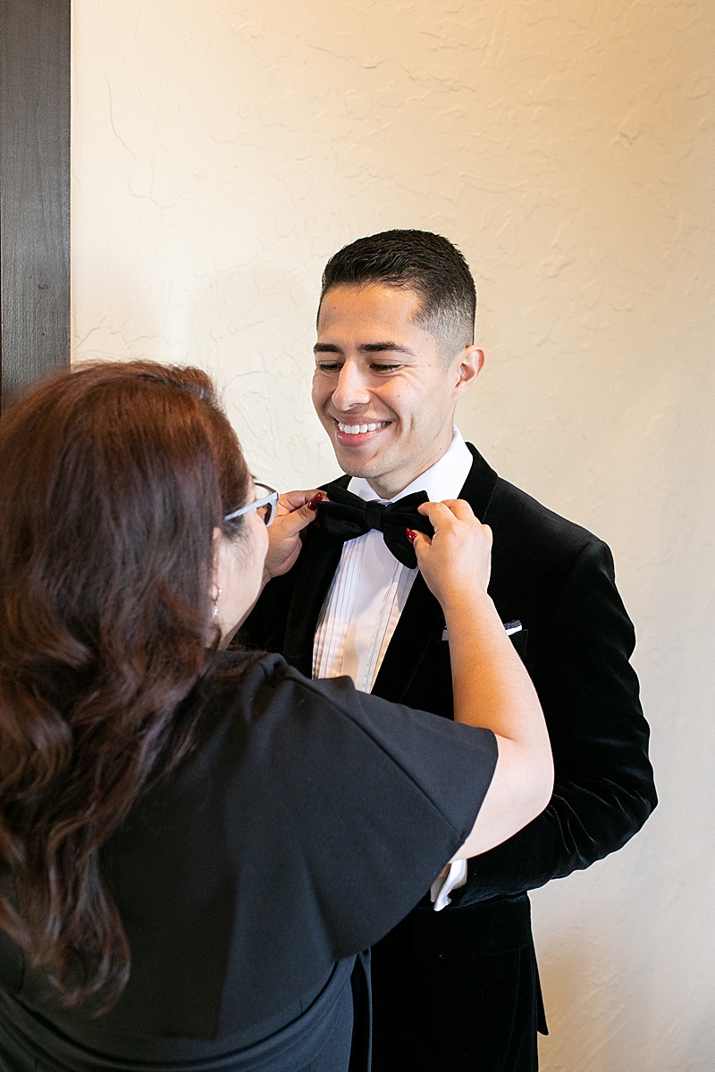 mother of the groom adjusts groom's tie on wedding day