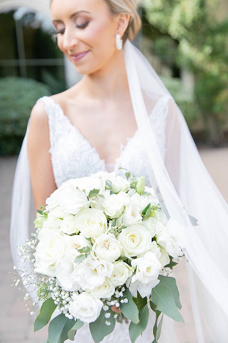 bride with all white bouquet poses outside Chapel at Ana Villa