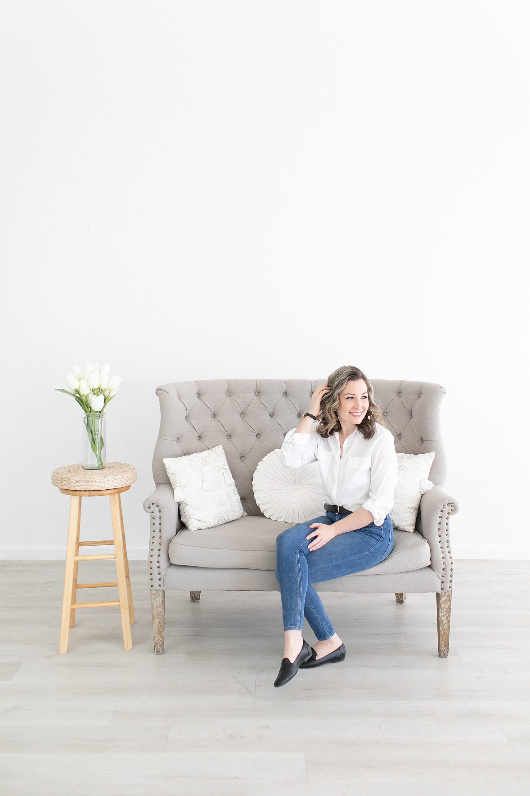wedding planner sits on couch during branding session