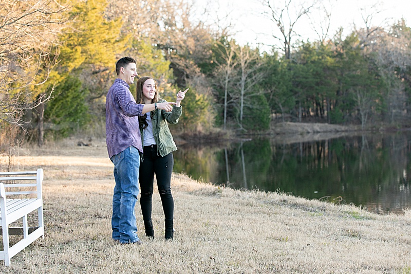 couple admires ring next to the lake