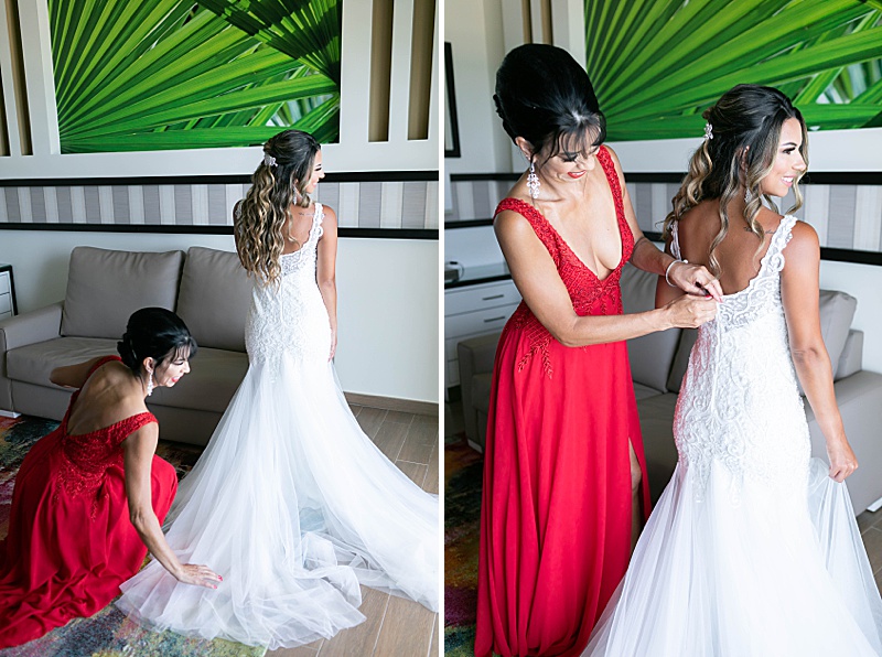 mother of the bride helps bride with wedding gown