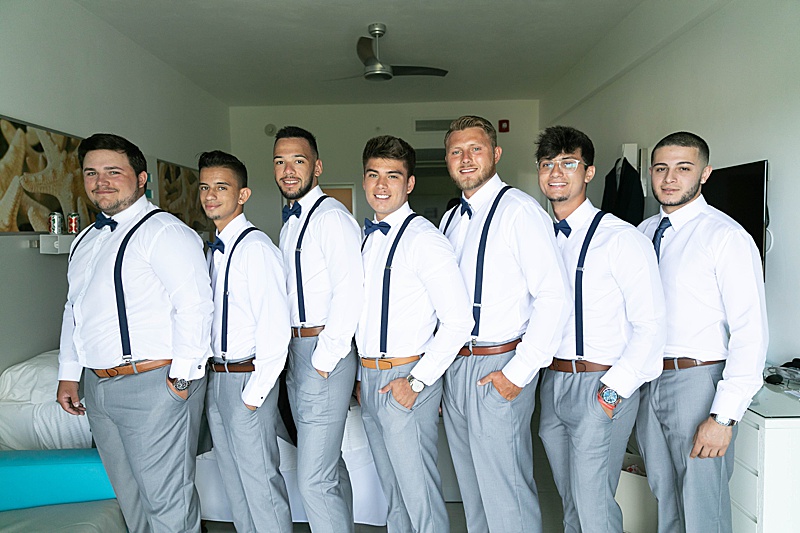 groomsmen pose in suspenders