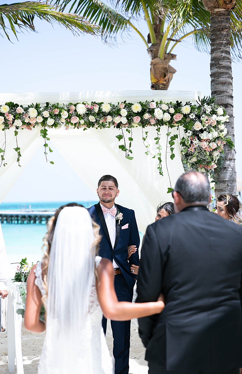 groom cries watching bride enter beach wedding