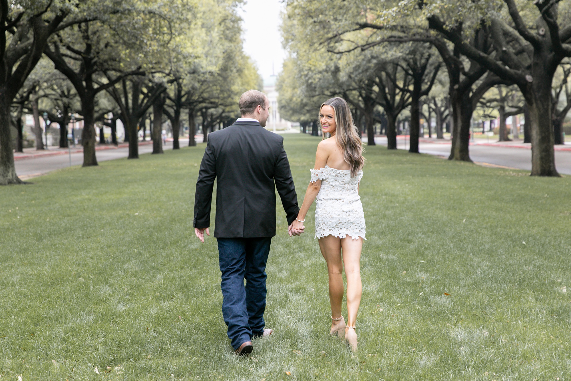 bride and groom walk through field at SMU Dallas