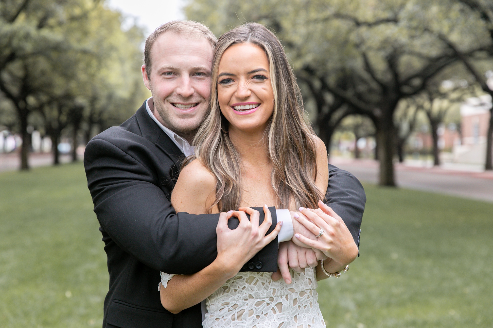 engaged couple snuggles and smiles at Texas photographer