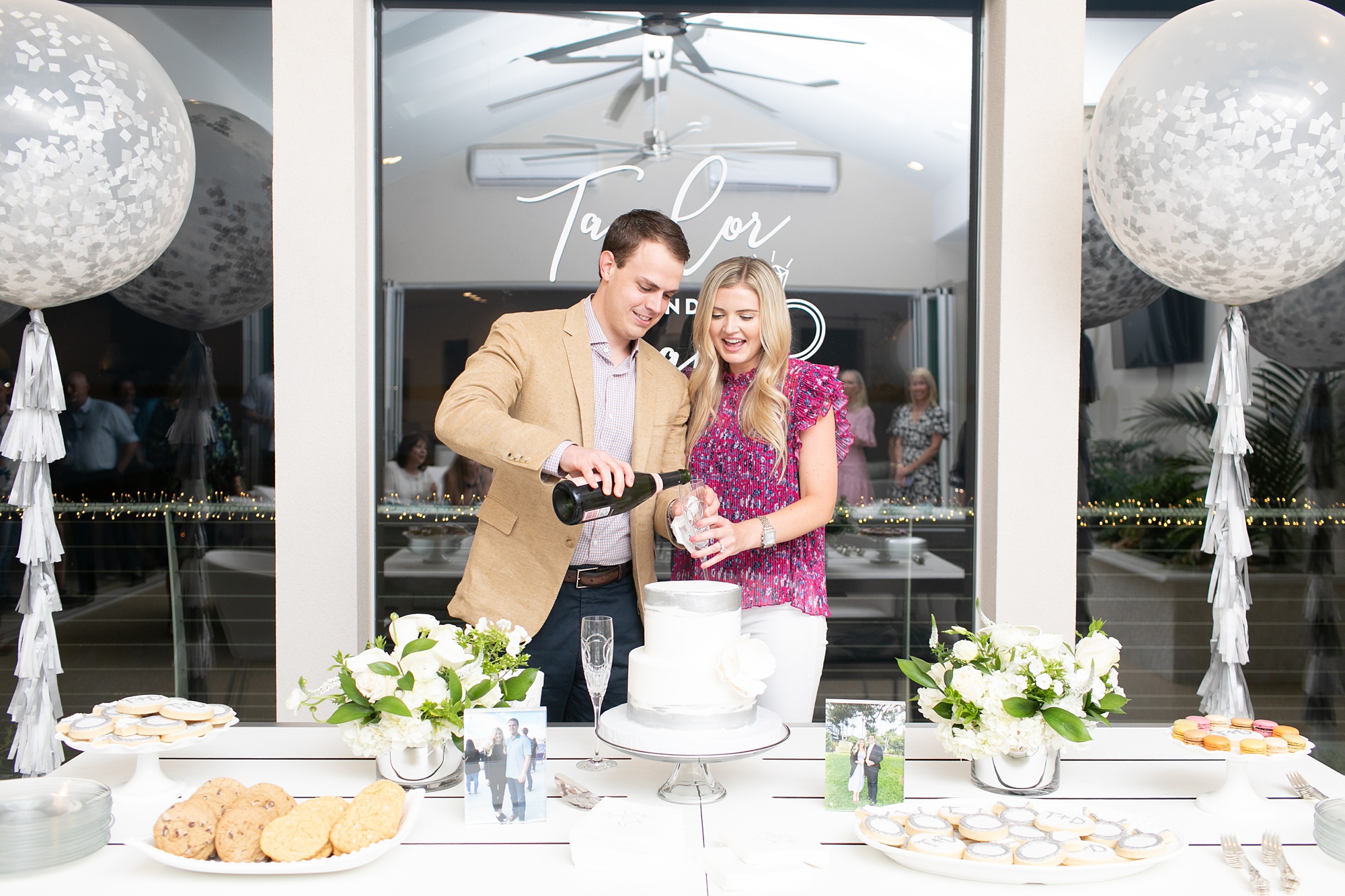 engaged couple pours drinks by dessert table