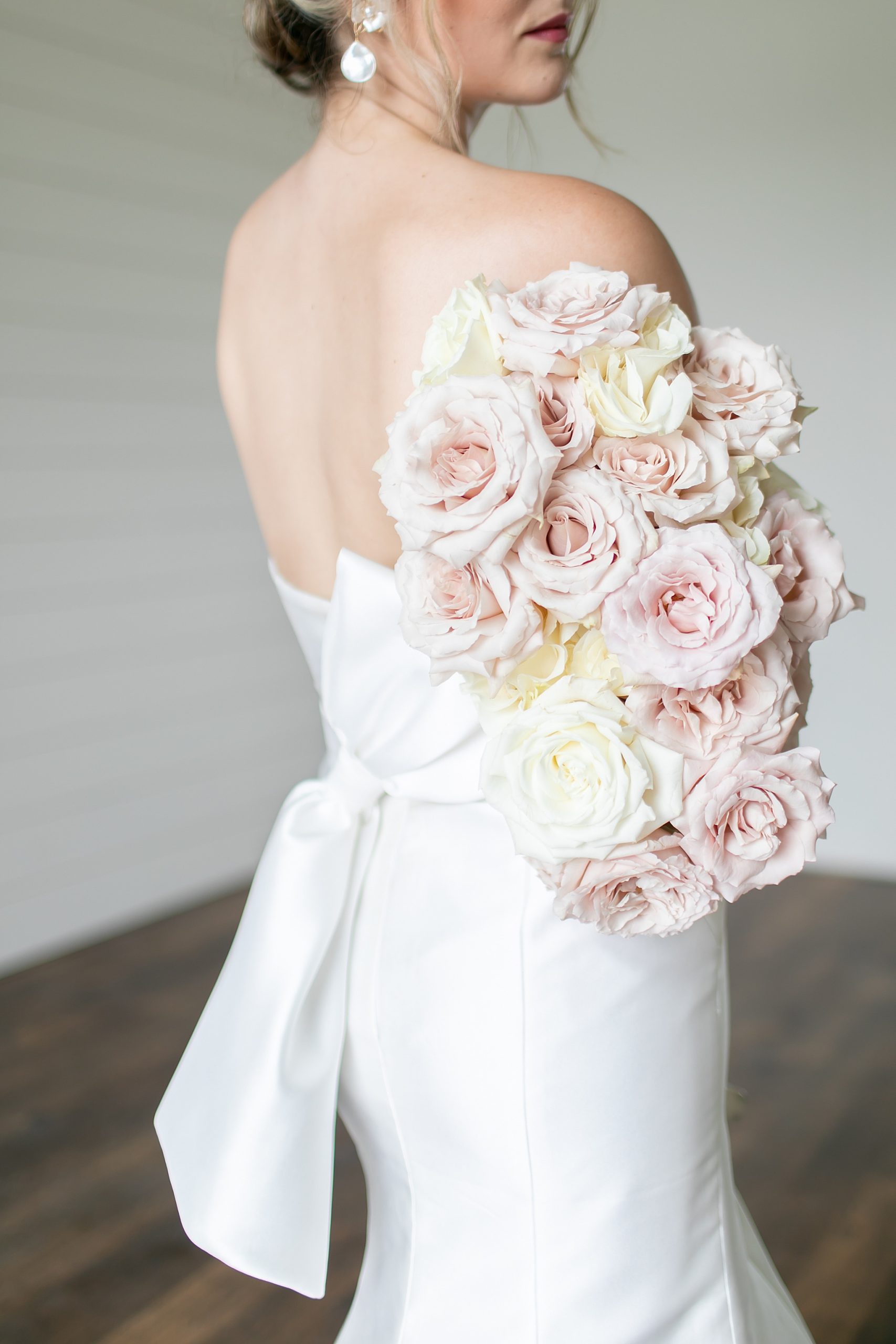bride holds bouquet of pink roses