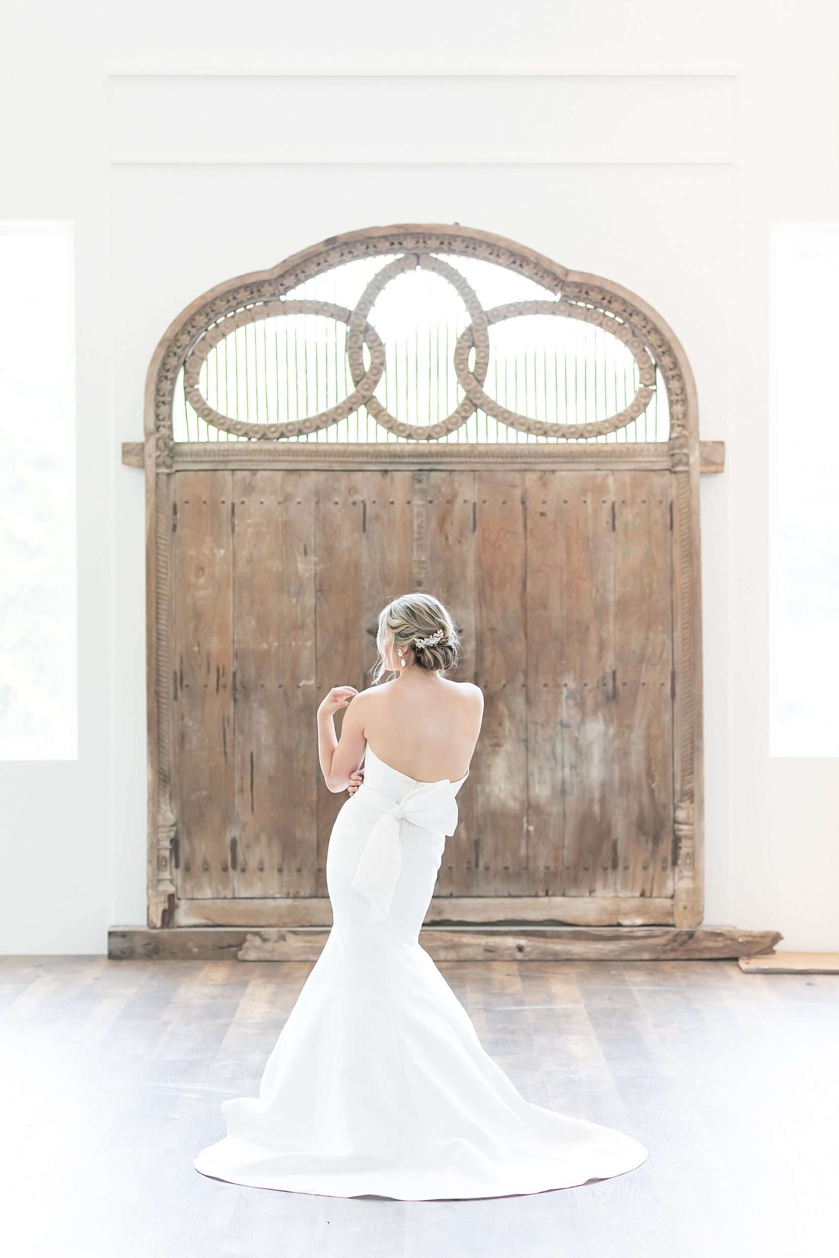 bride poses by rustic wooden door outside