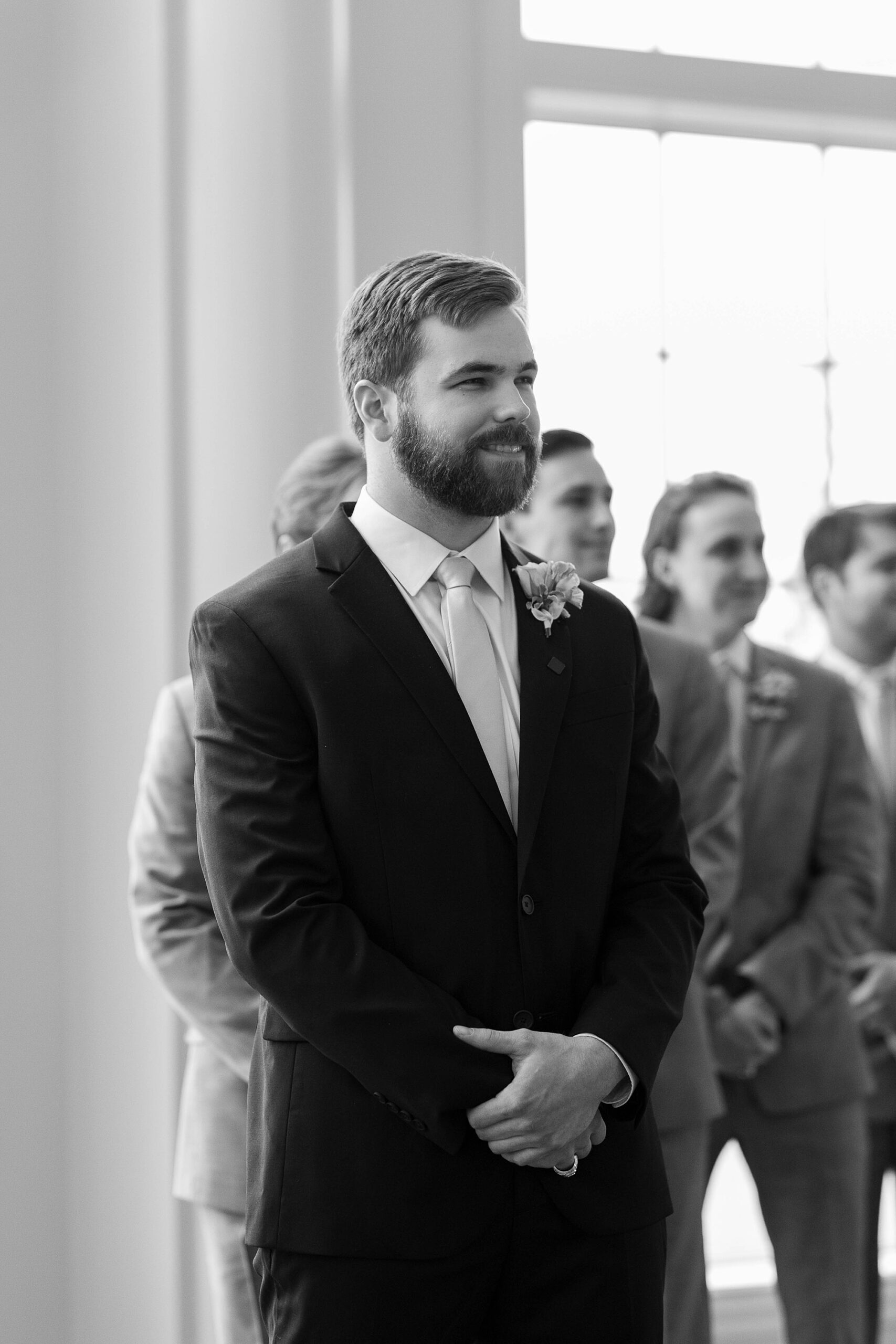 groom stands watching bride walk down aisle for ceremony at the Hillside Estate