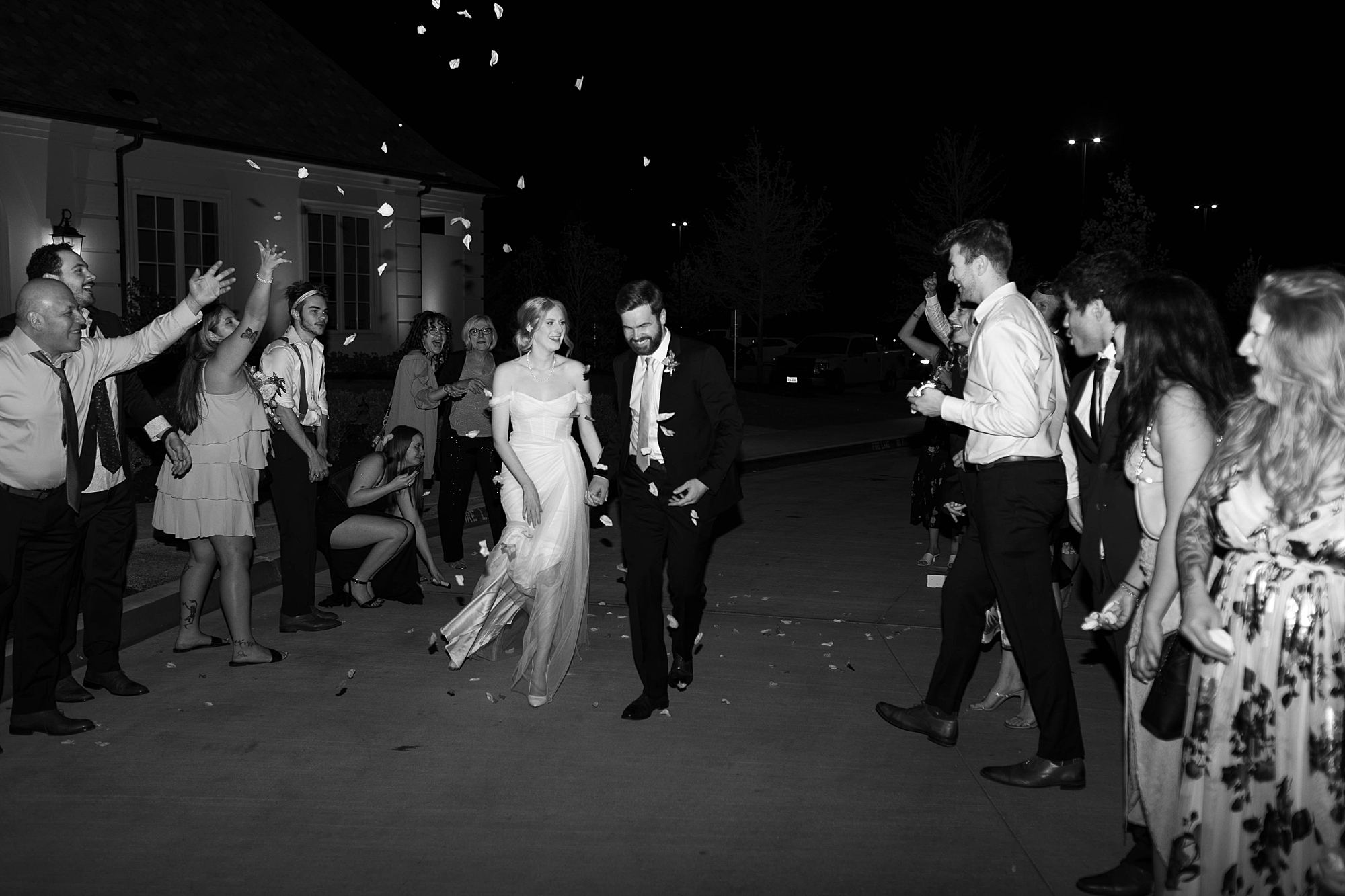 newlyweds hold hands leaving Denton TX wedding reception in bubble exit 