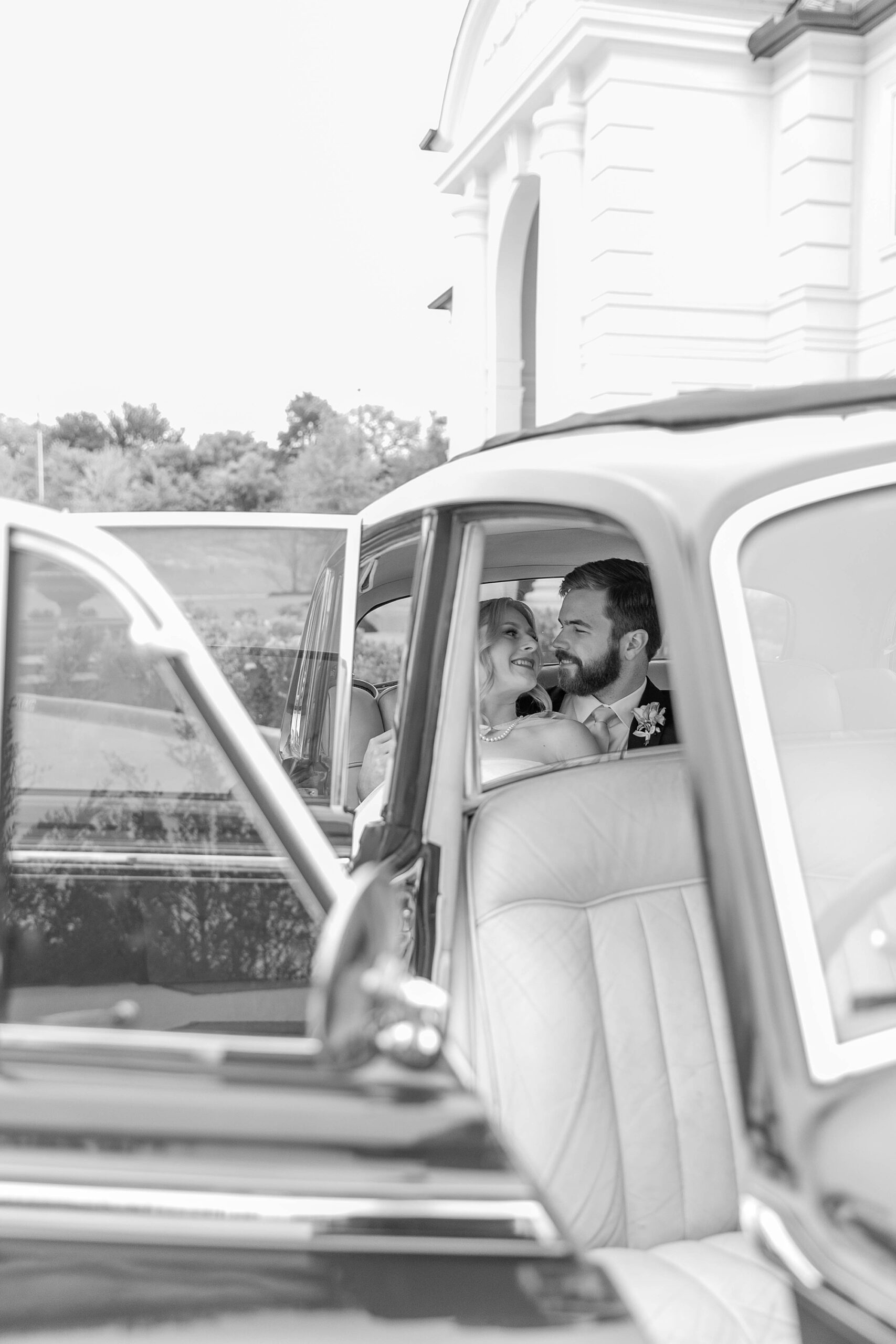 bride and groom kiss in back of car during portraits in Texas 