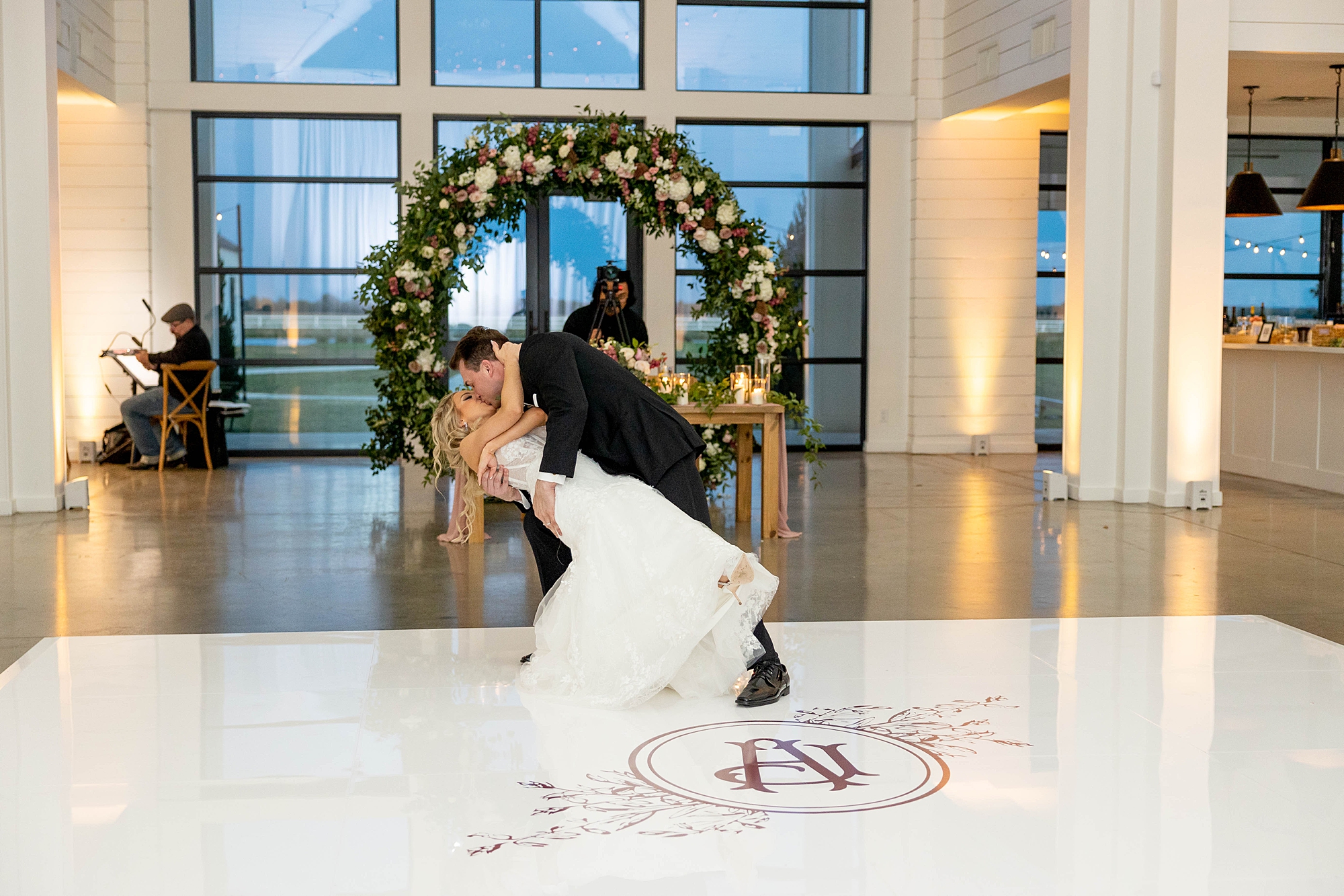 groom dips bride on custom floor by sweetheart table 