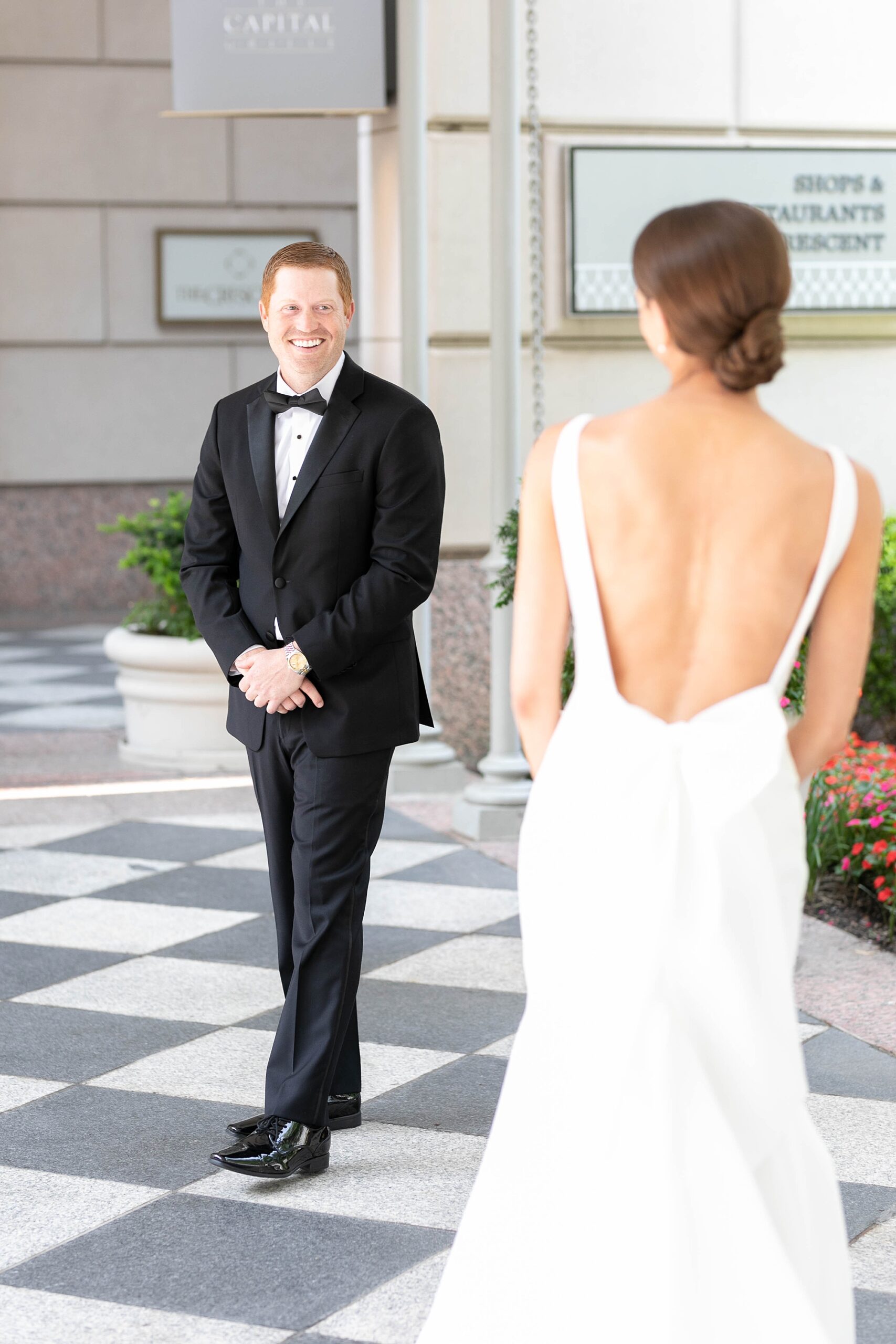 groom turns to look at bride during first look outside the Hotel Crescent Court
