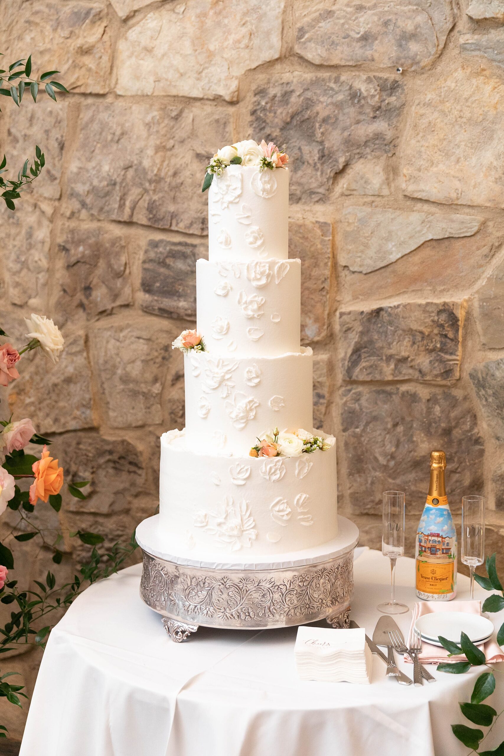tiered white wedding cake on silver platter for wedding reception in the barn at the Hotel Drover