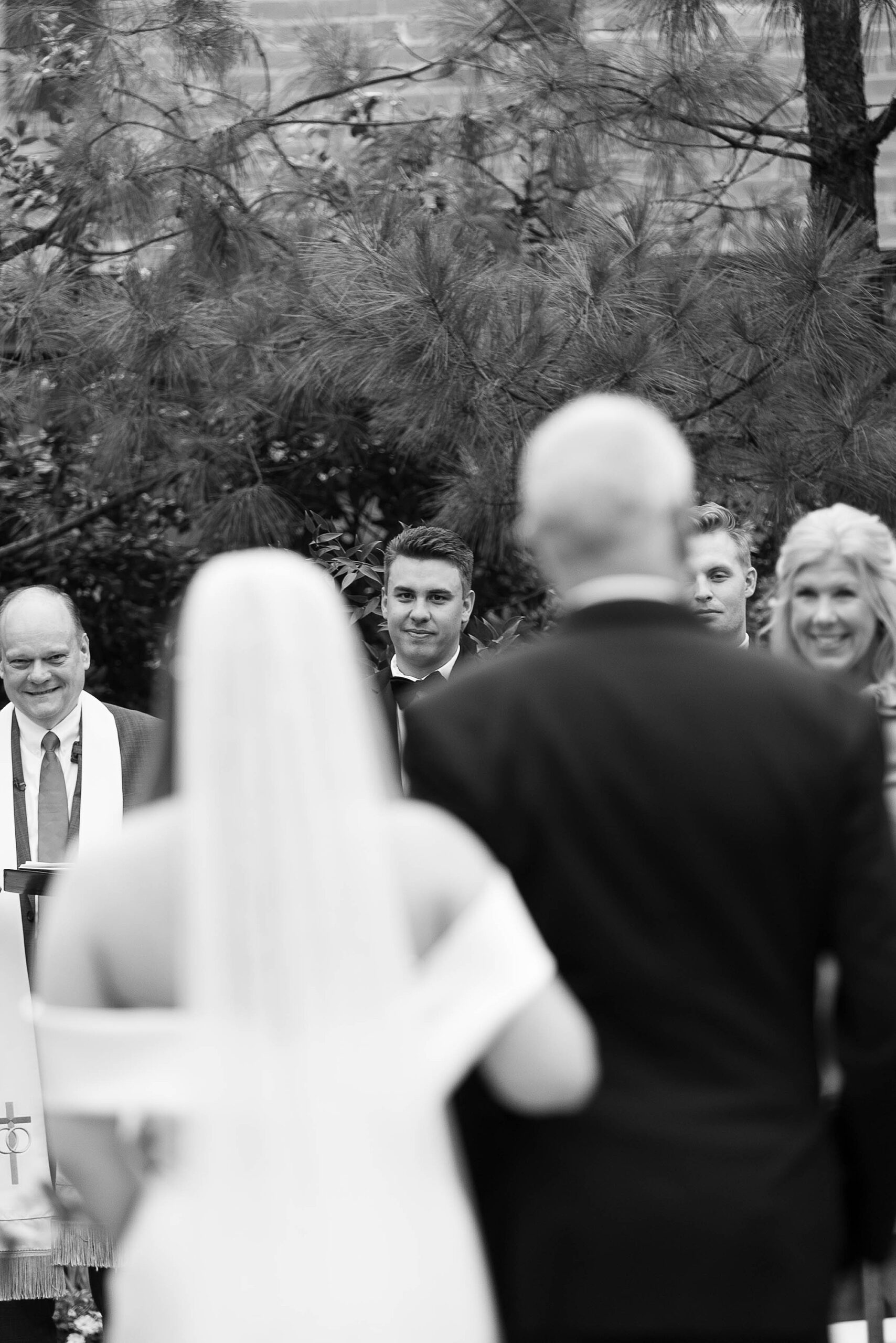groom watches bride walk down the aisle to him