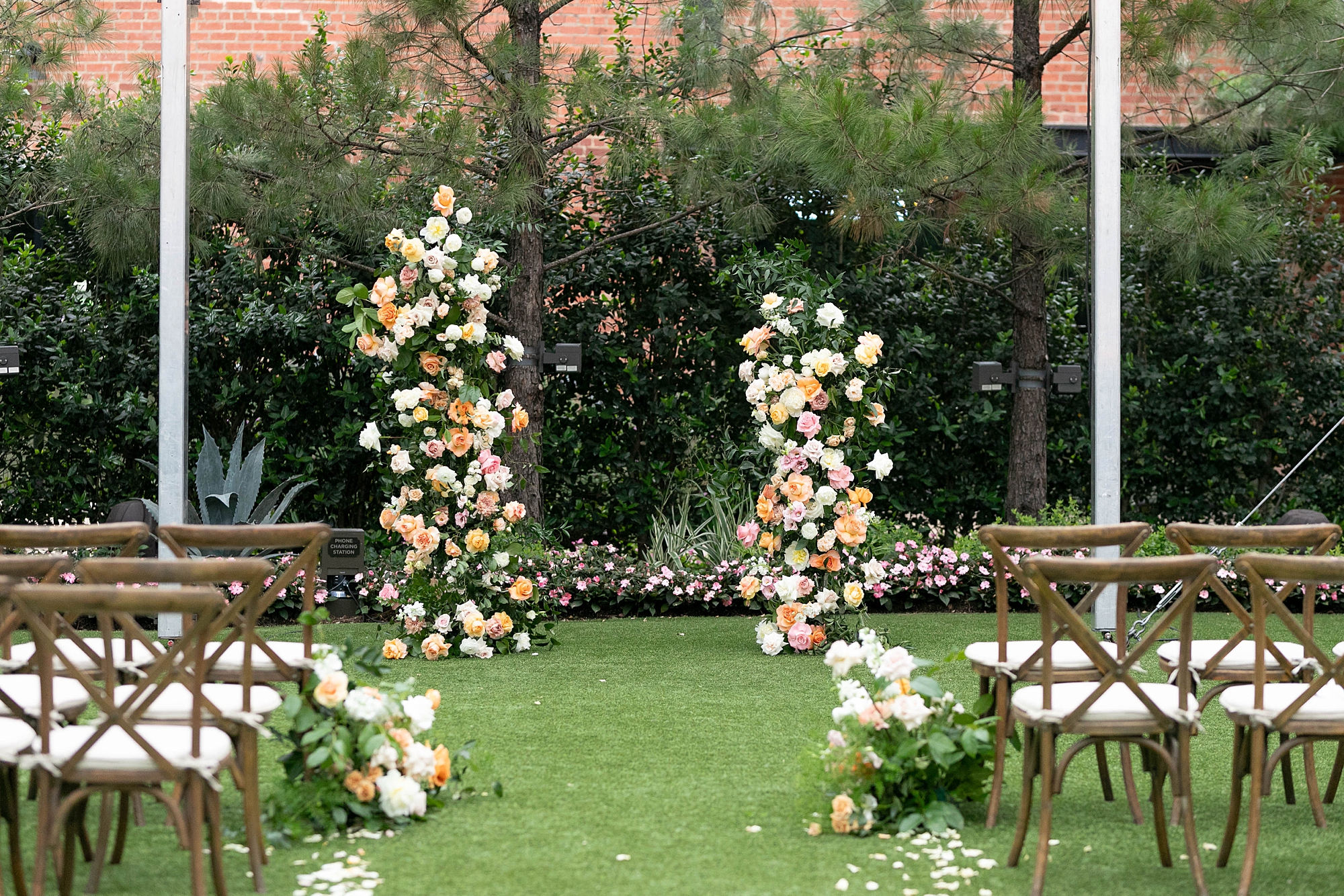 floral arrangements at the end of the aisle with wooden chairs 