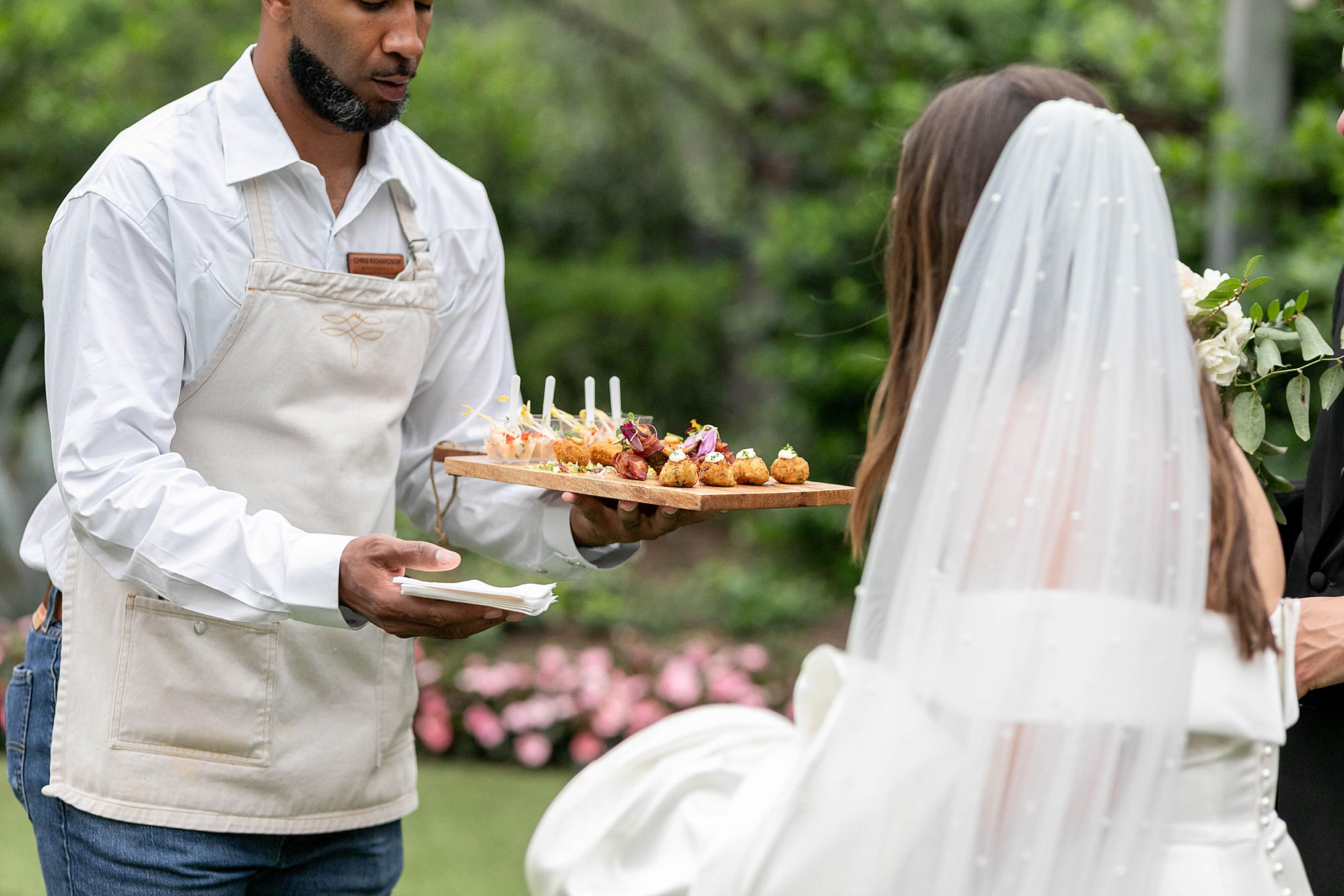 waiter provides appetizers to bride and groom 