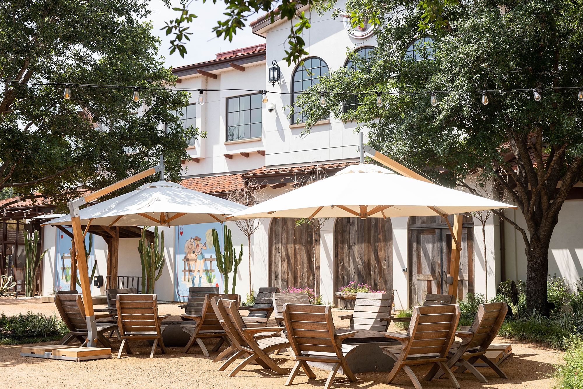 patio with white umbrellas and wooden chairs at the Hotel Drover
