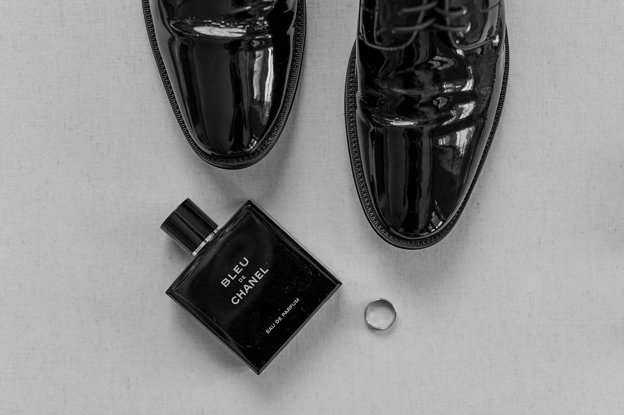 groom's shiny black shoes and cologne 