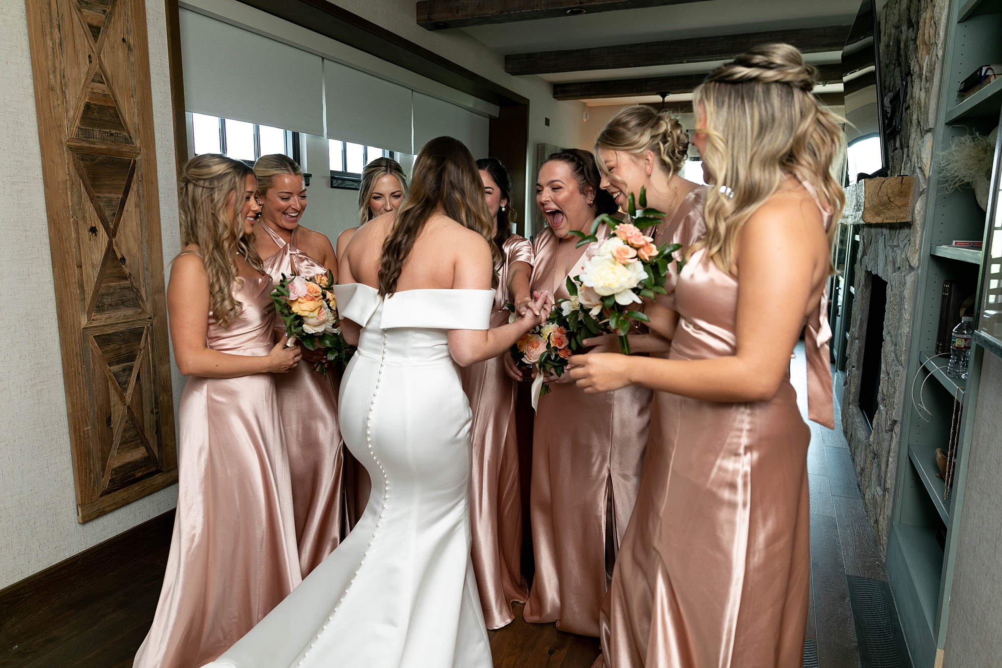 bride shows wedding dress to bridesmaids during first look 