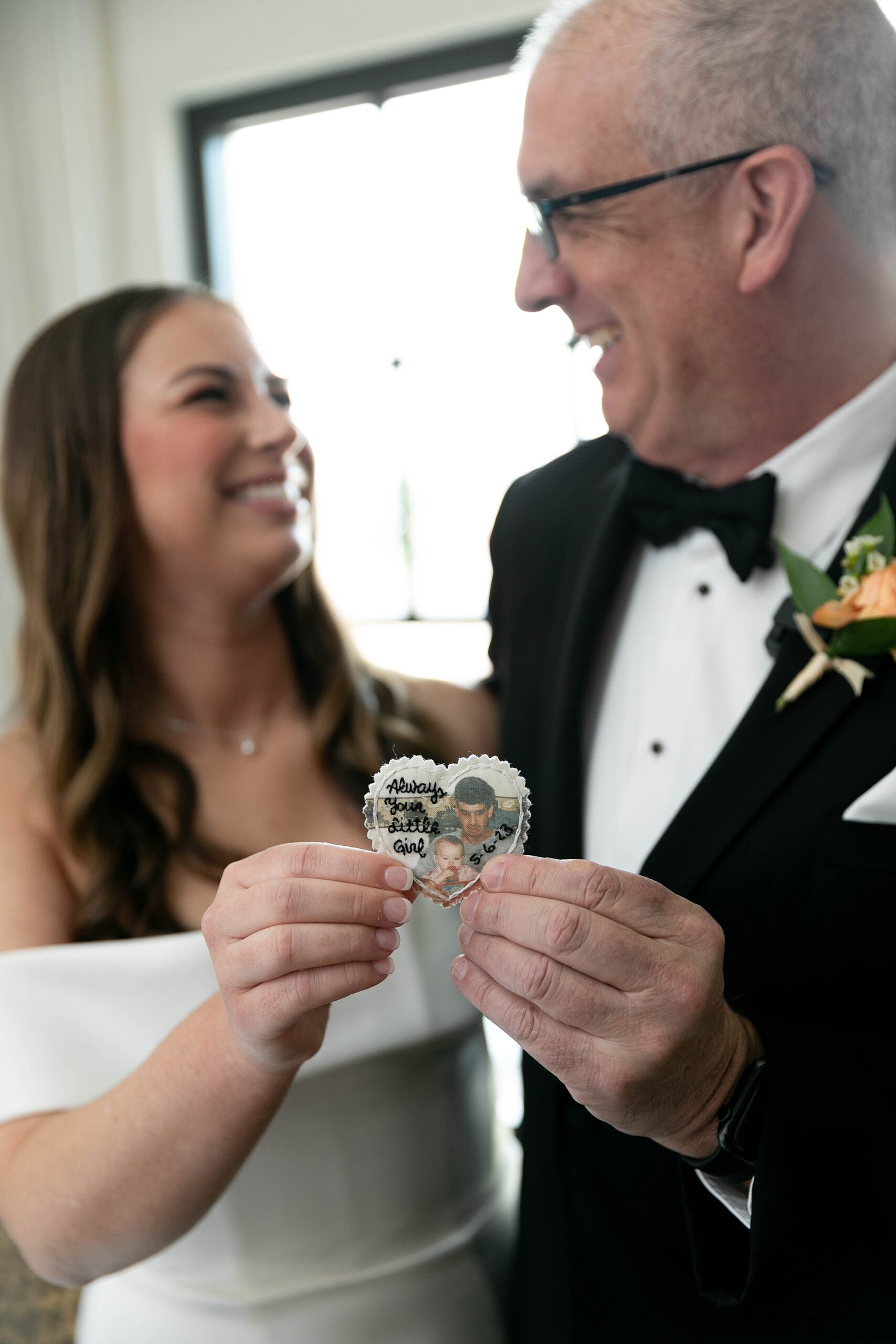father and bride smile holding custom gift 