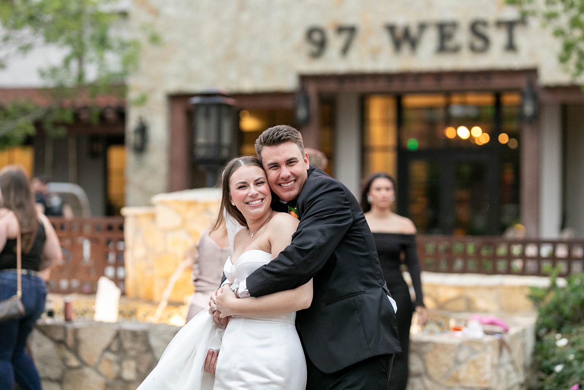 groom hugs bride from behind during wedding portraits at the Hotel Drover