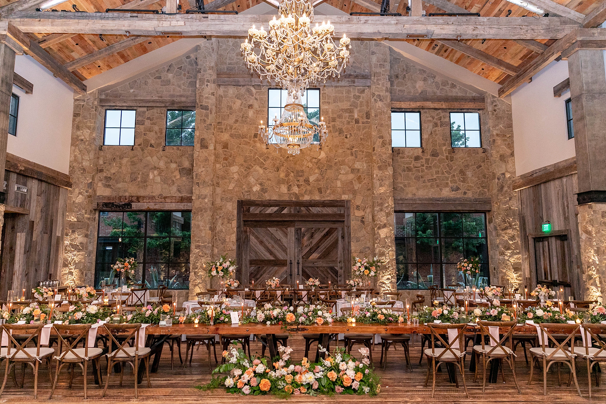 wedding reception in the barn at the Hotel Drover with pink, yellow, and peach flowers 