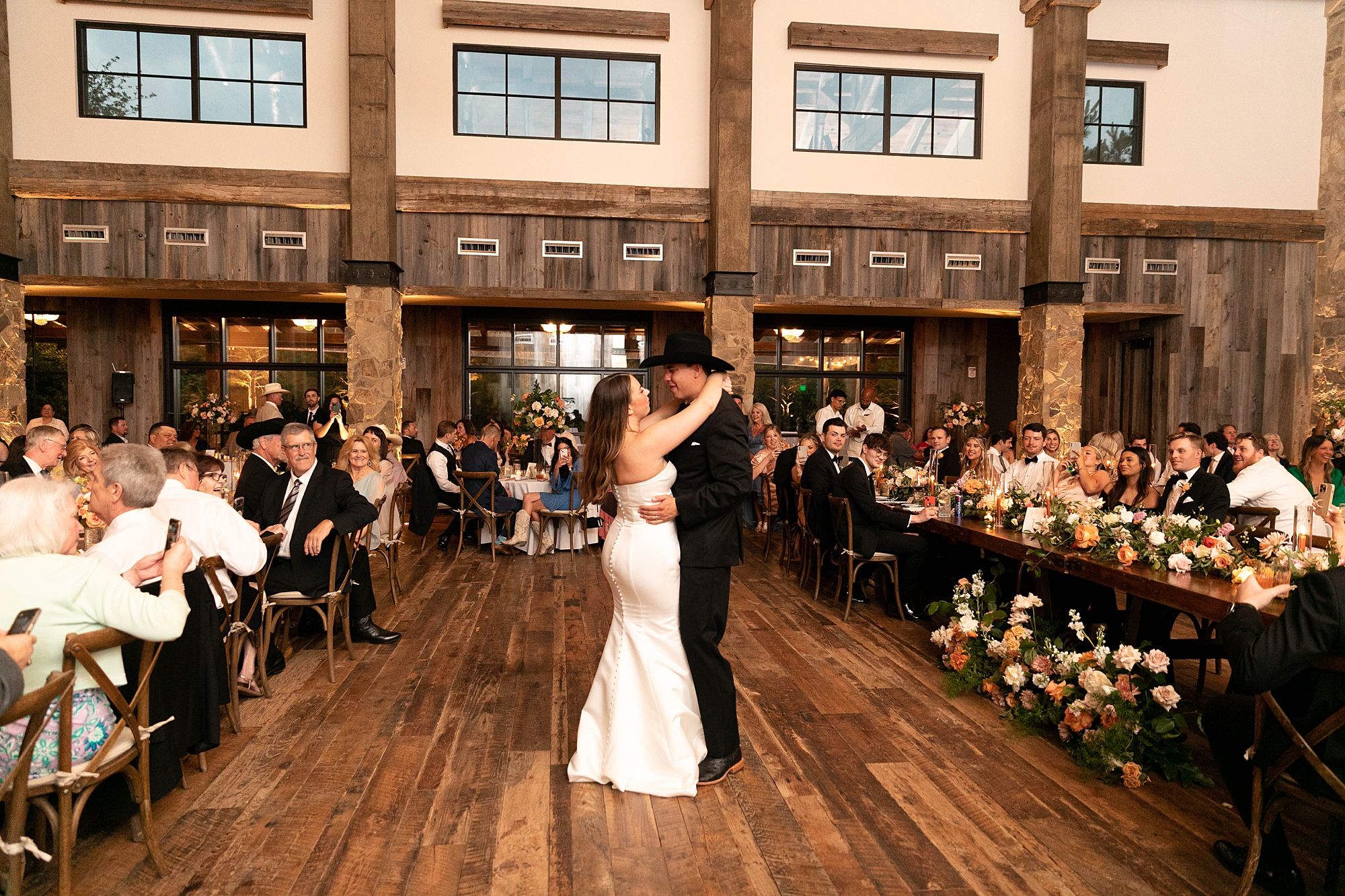 newlyweds have first dance during wedding reception in the barn at the Hotel Drover